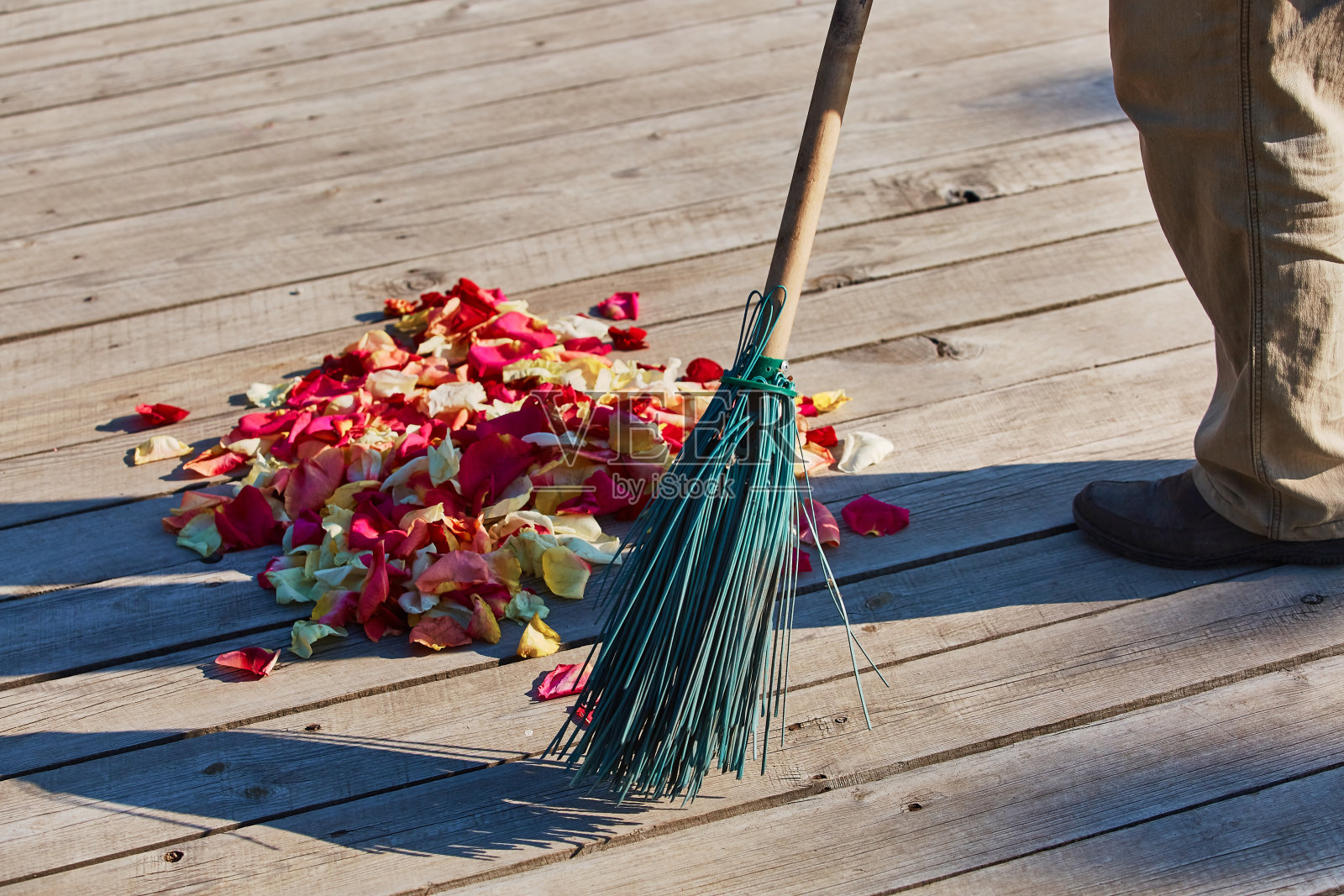 婚礼后，用扫帚扫五颜六色的玫瑰花瓣照片摄影图片