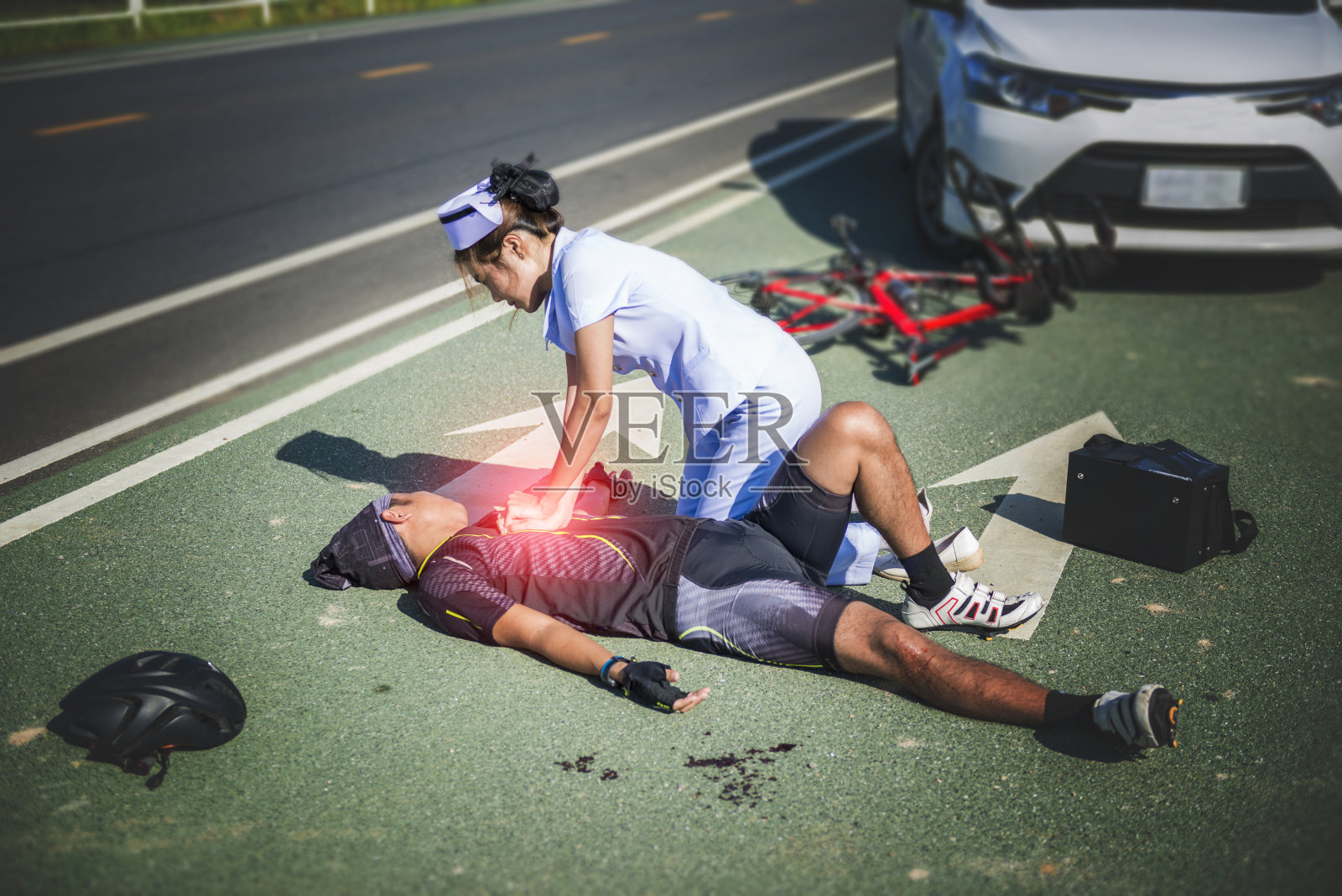 女护士帮助紧急CRP对自行车男子在事故照片摄影图片