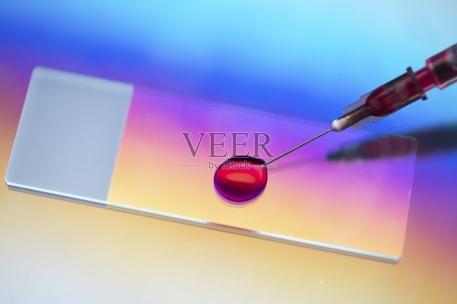 显微镜载玻片与血样注射器在微光下照片摄影图片