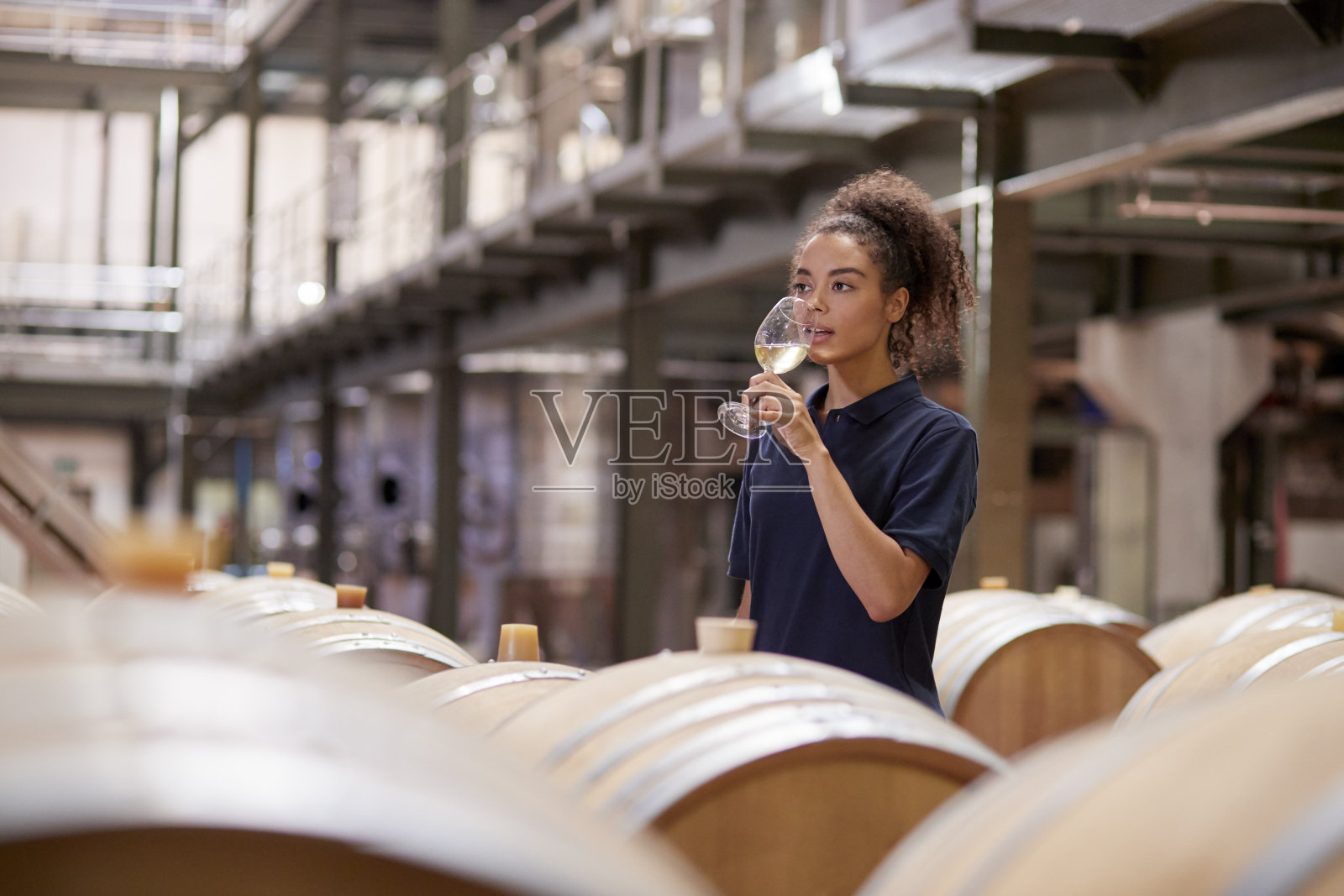 年轻女子品酒在葡萄酒工厂的仓库照片摄影图片