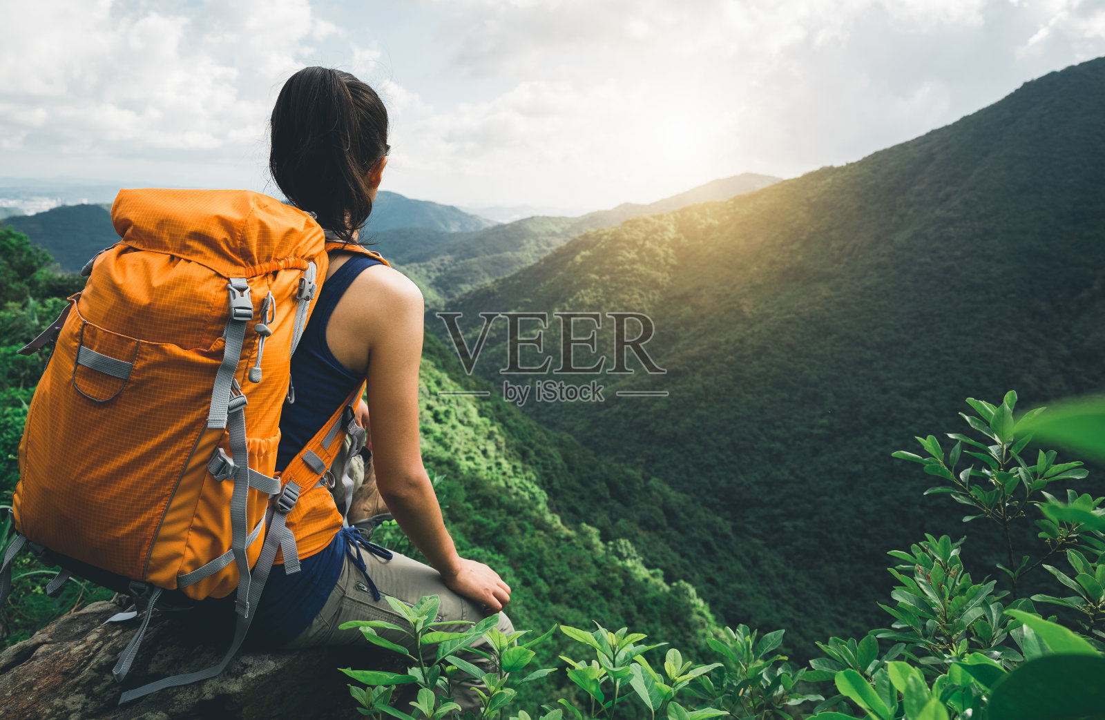 一位年轻的背包客在山顶欣赏风景照片摄影图片