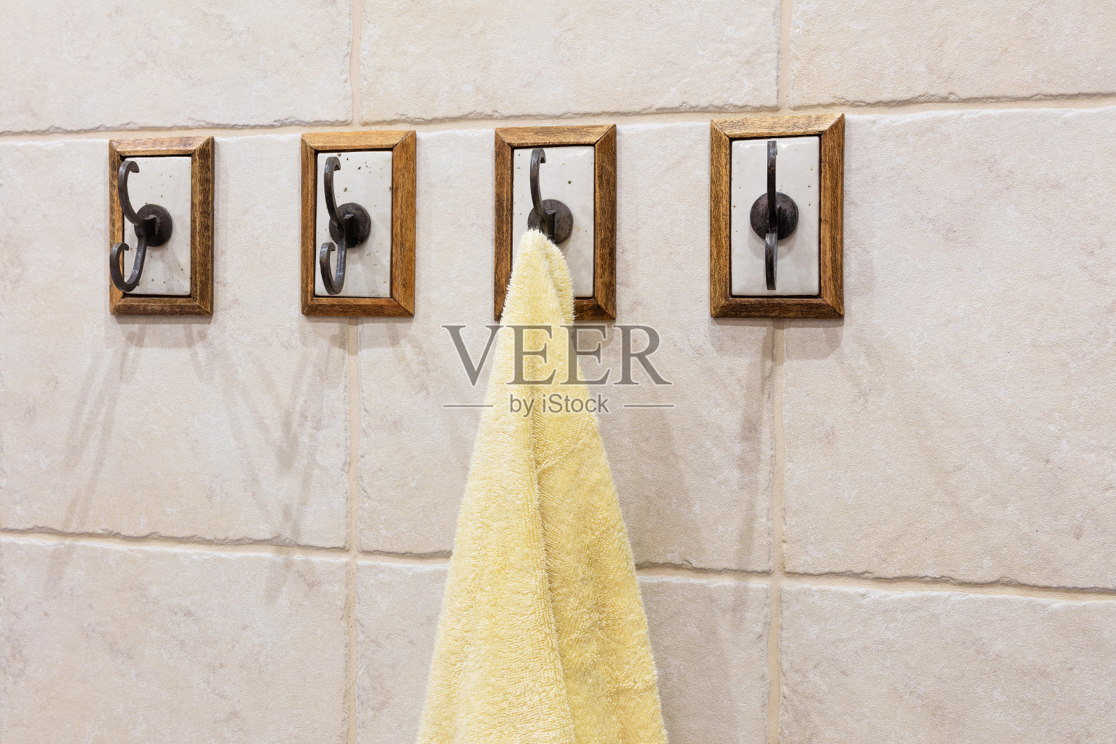 浴室墙上有四个挂钩，上面挂着毛巾照片摄影图片