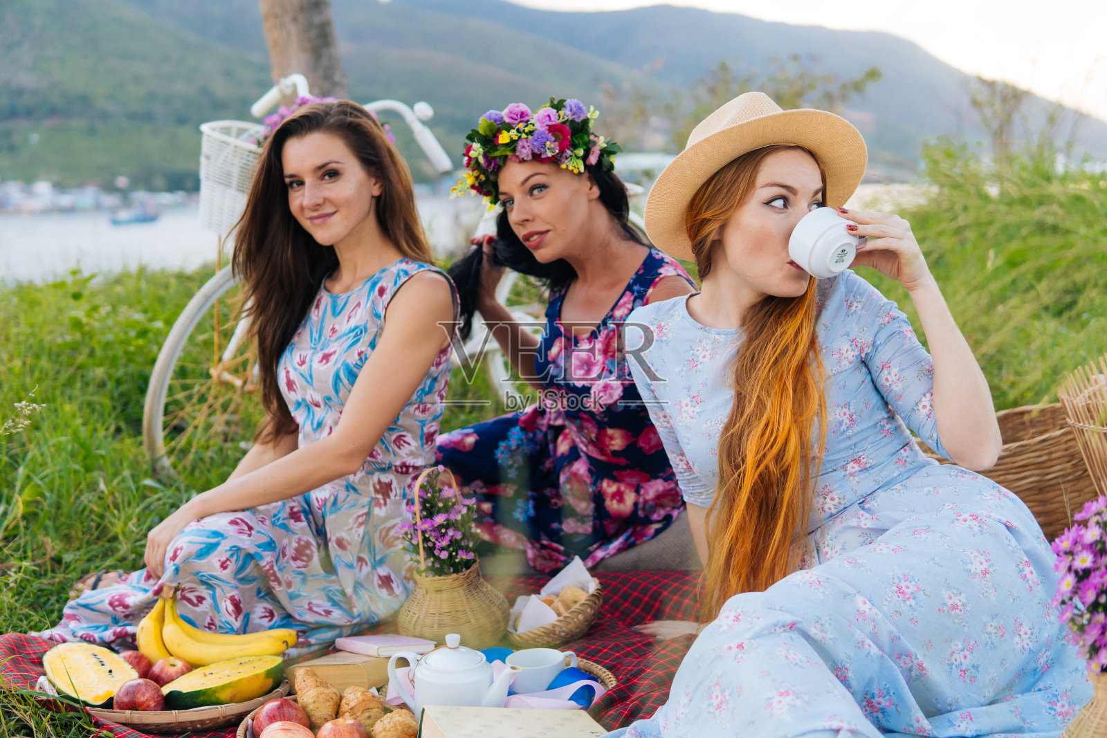 女人享受野餐在农村-三个女孩度假有乐趣。照片摄影图片