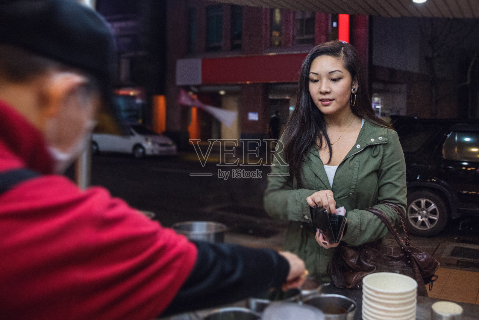 亚洲女人晚上在台北市中心-台湾购买街头食品从一个小贩照片摄影图片