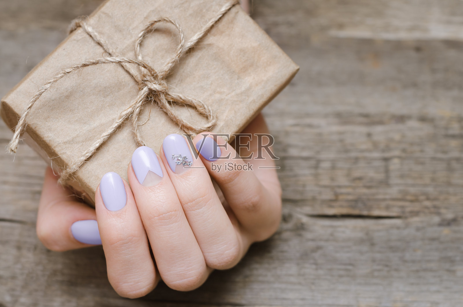 女性的手与浅紫色指甲设计照片摄影图片