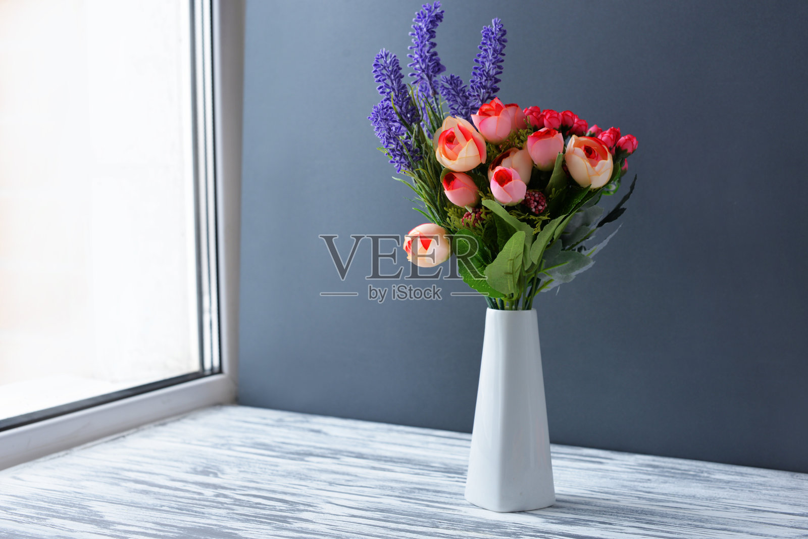 花瓶上有花，紫色，淡紫色，薰衣草，在一个漂亮的白色花瓶上，木制的背景照片摄影图片