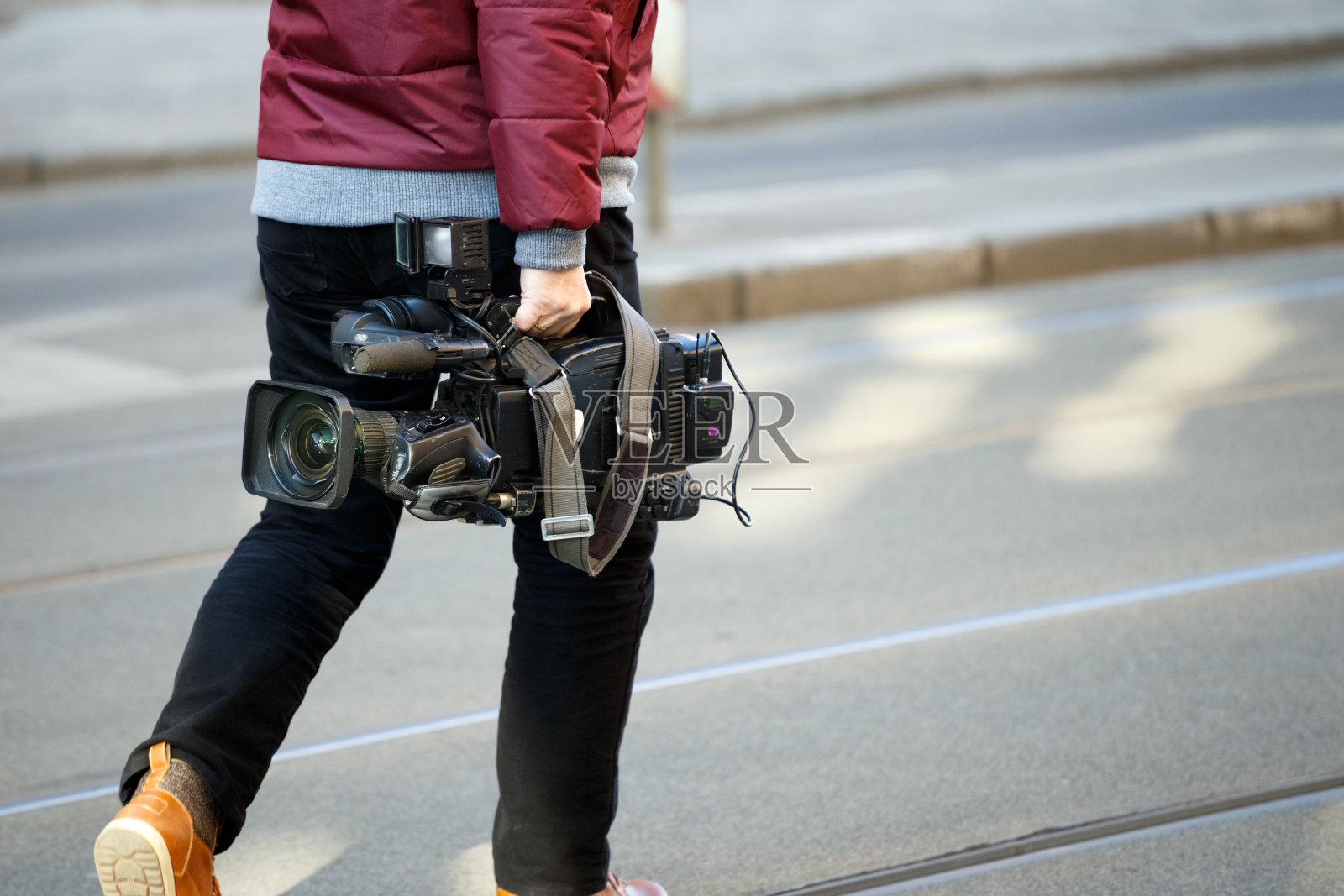 一个拿着他的专业摄像机在街上的摄影师照片摄影图片