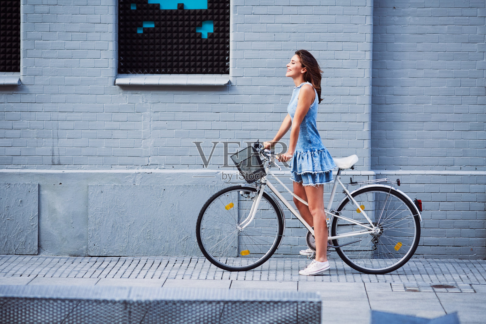 夏天在城市里骑自行车的女人照片摄影图片
