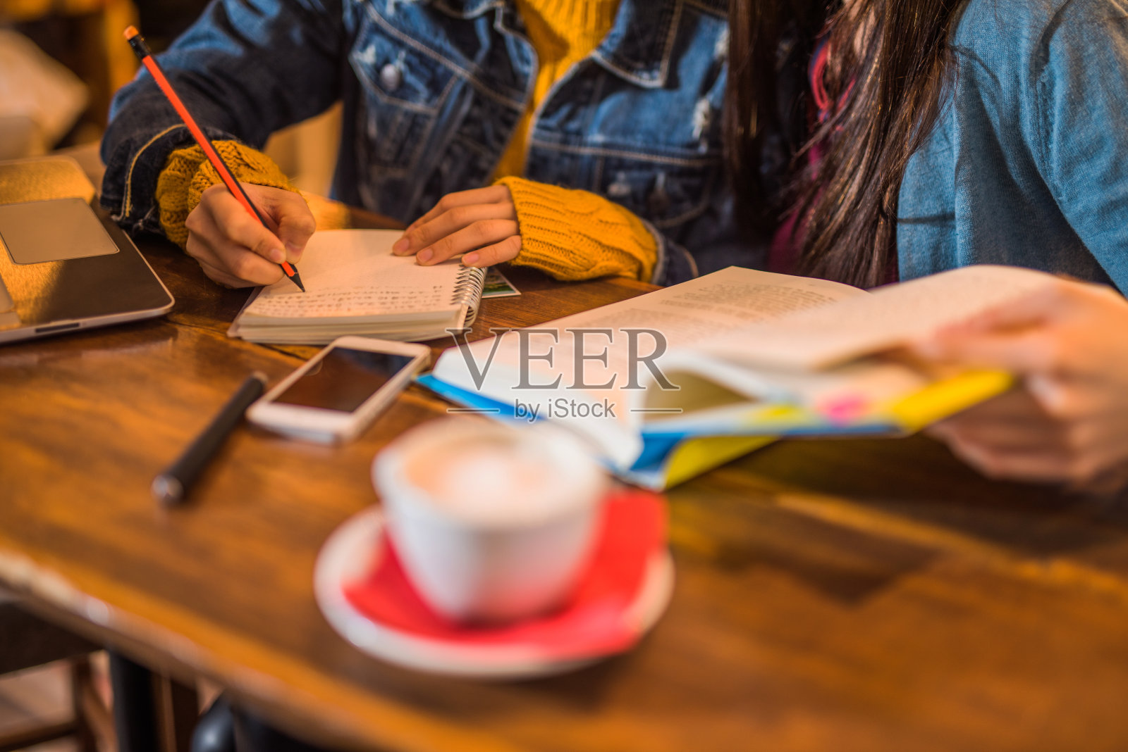 两个女人一起在咖啡馆学习的特写。照片摄影图片