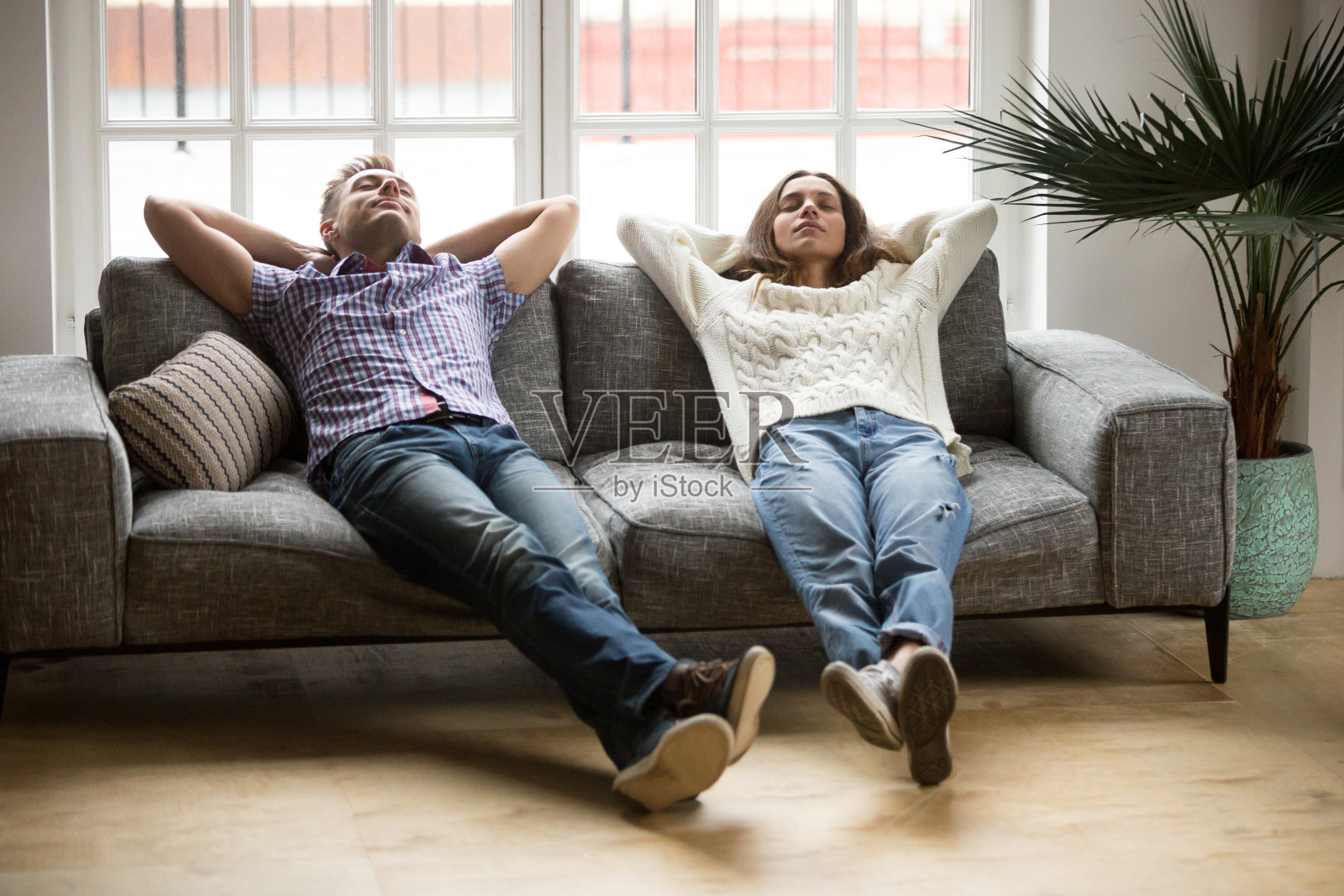 一对年轻夫妇一起在沙发上放松，享受着呼吸空气的乐趣照片摄影图片
