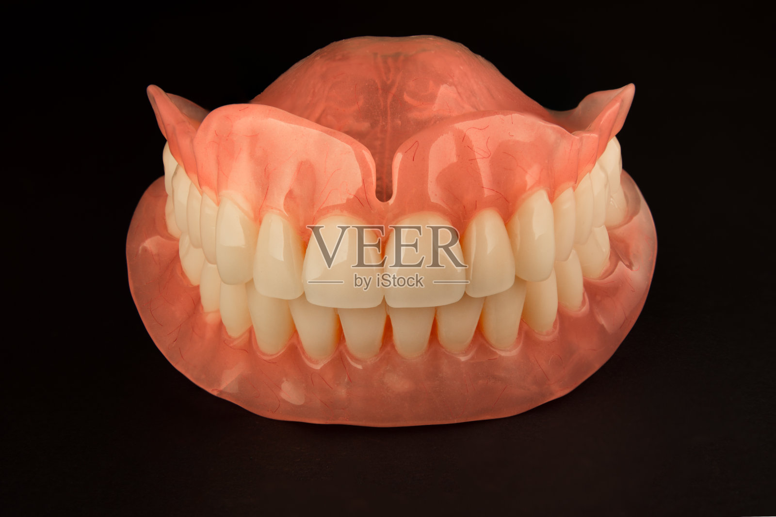 假牙。孤立在白色背景下的人颌骨丙烯酸假体。矫形牙科的概念照片摄影图片