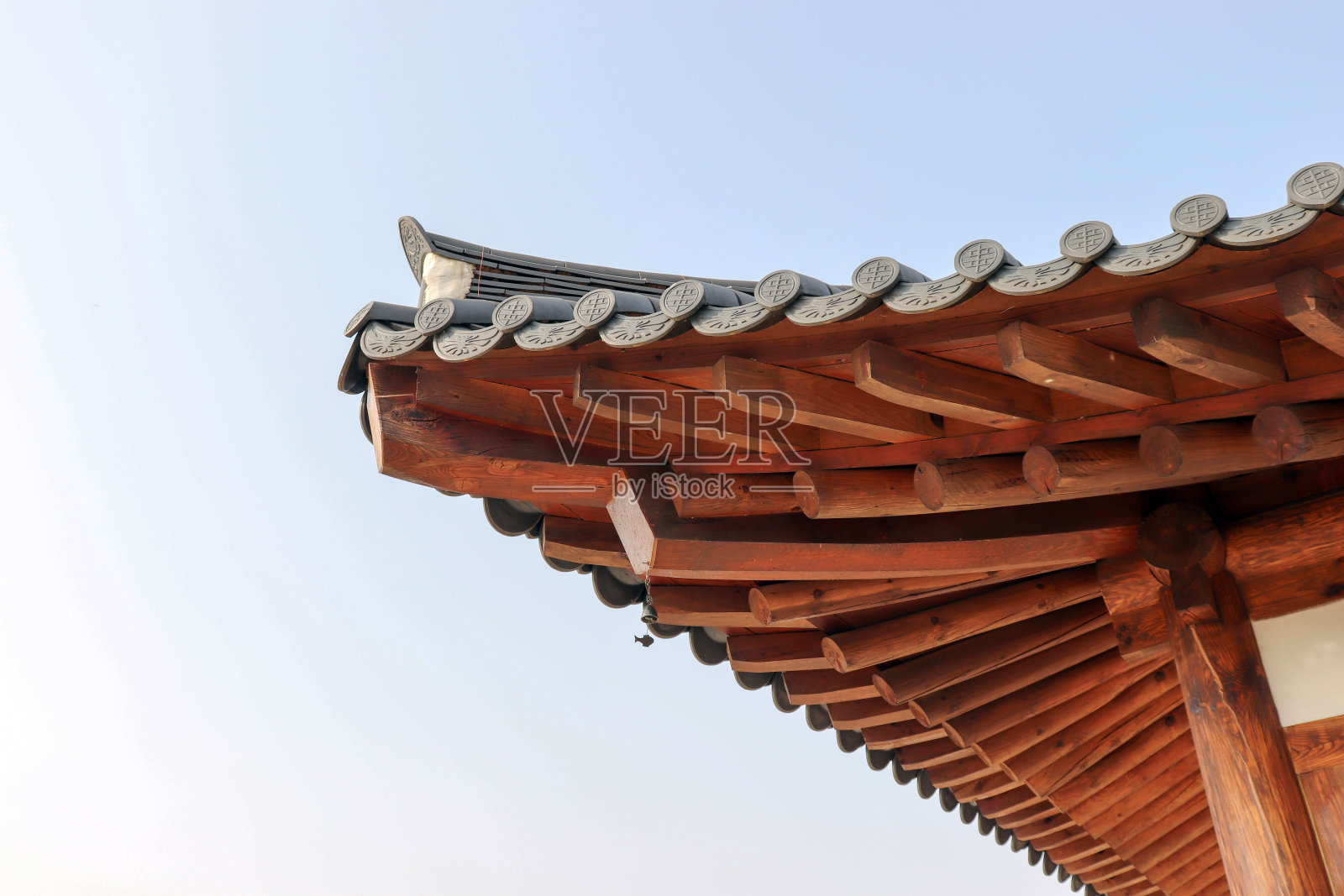 以蓝天为背景的韩国传统房屋的屋檐。照片摄影图片
