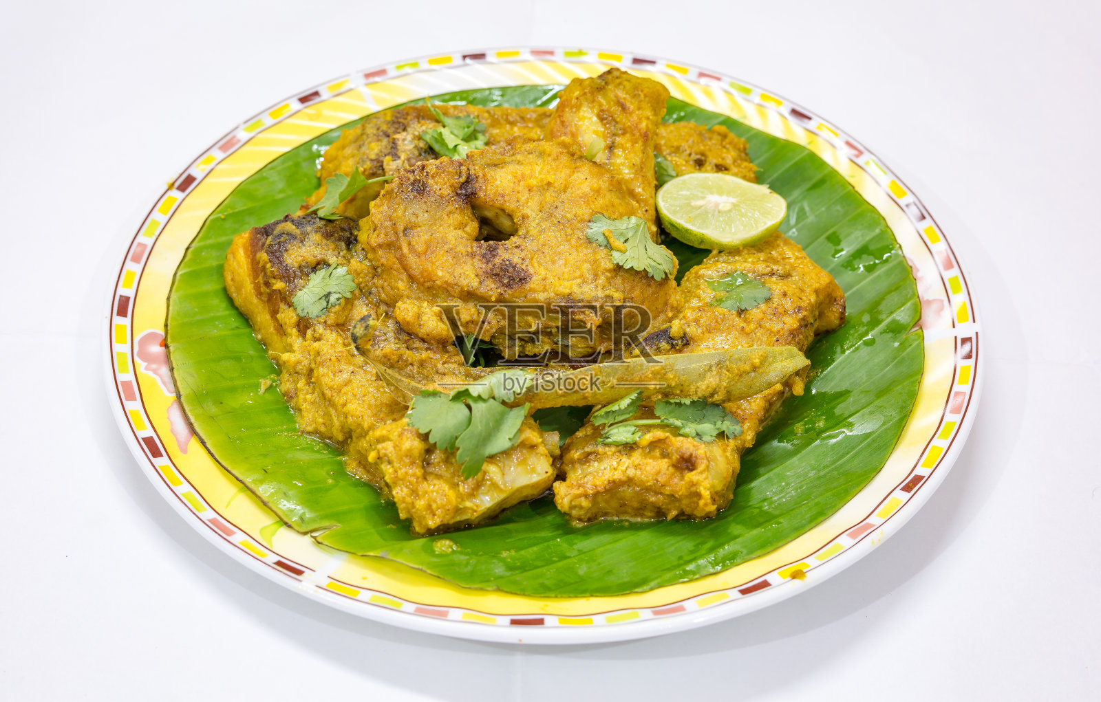 美味的孟加拉菜，马萨拉罗胡鱼咖喱芭蕉叶，香菜和柠檬片。照片摄影图片