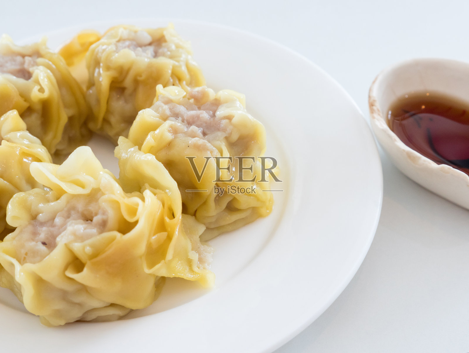白色盘子上的中国蒸饺。照片摄影图片
