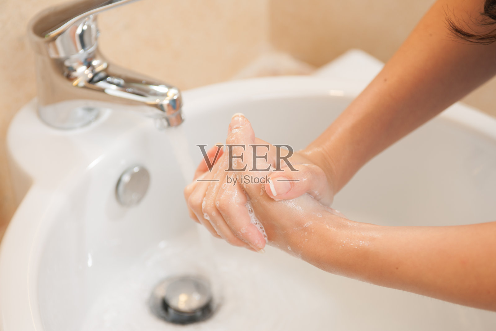 特写的女人洗手与肥皂在水槽照片摄影图片