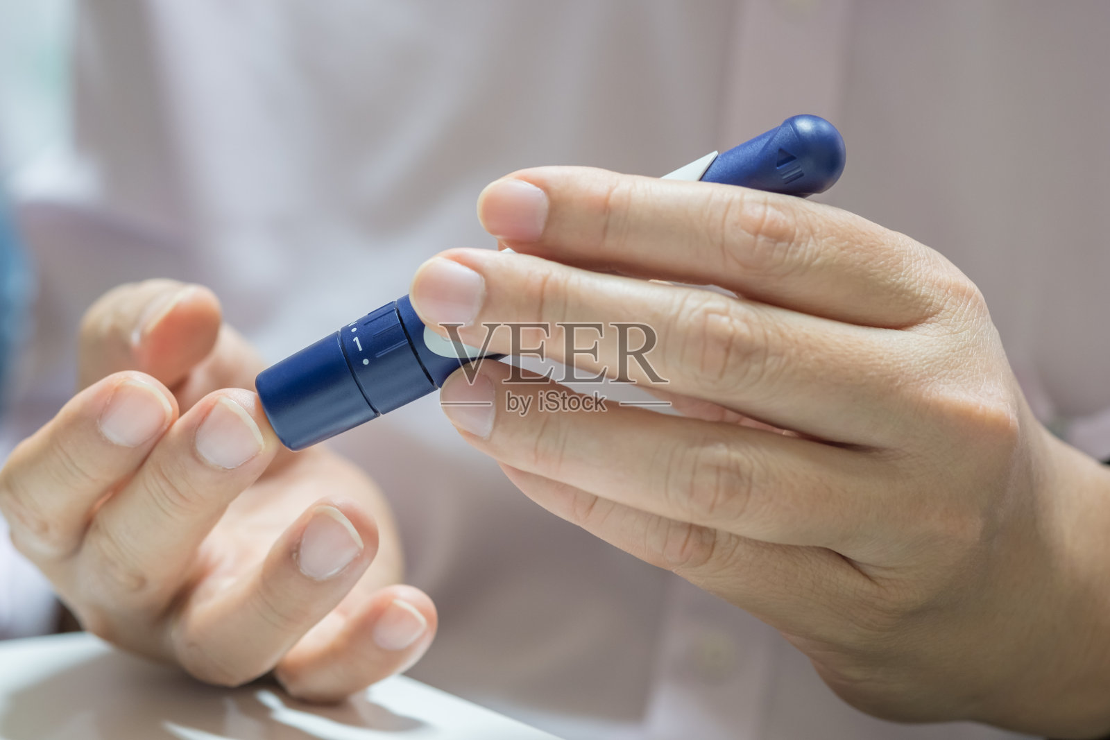 男人的手用刺针在手指上检查血糖水平，血糖仪使用作为药物，糖尿病，血糖，保健和人的概念。照片摄影图片