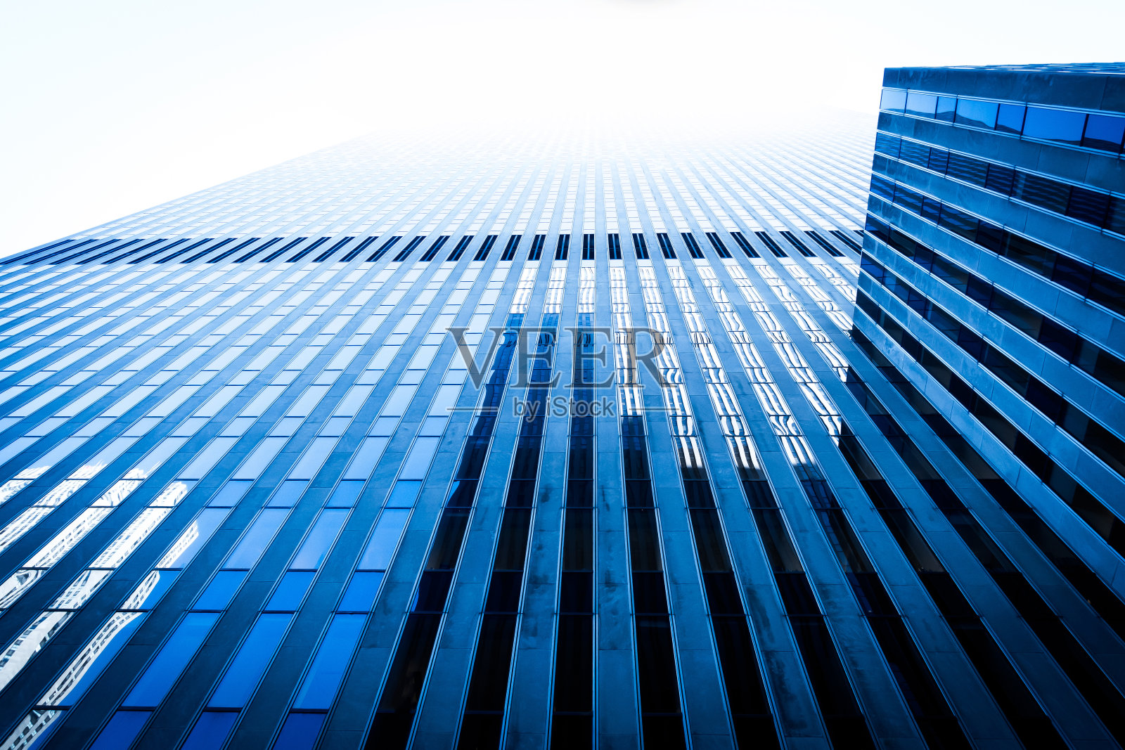 低角度的摩天大楼反光玻璃墙和窗户背景。现代建筑模式概念。照片摄影图片
