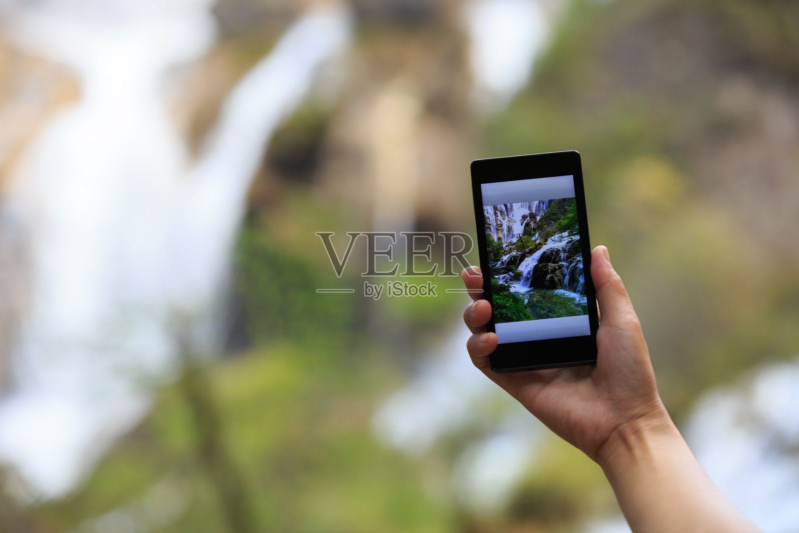 女游客用智能手机拍照照片摄影图片