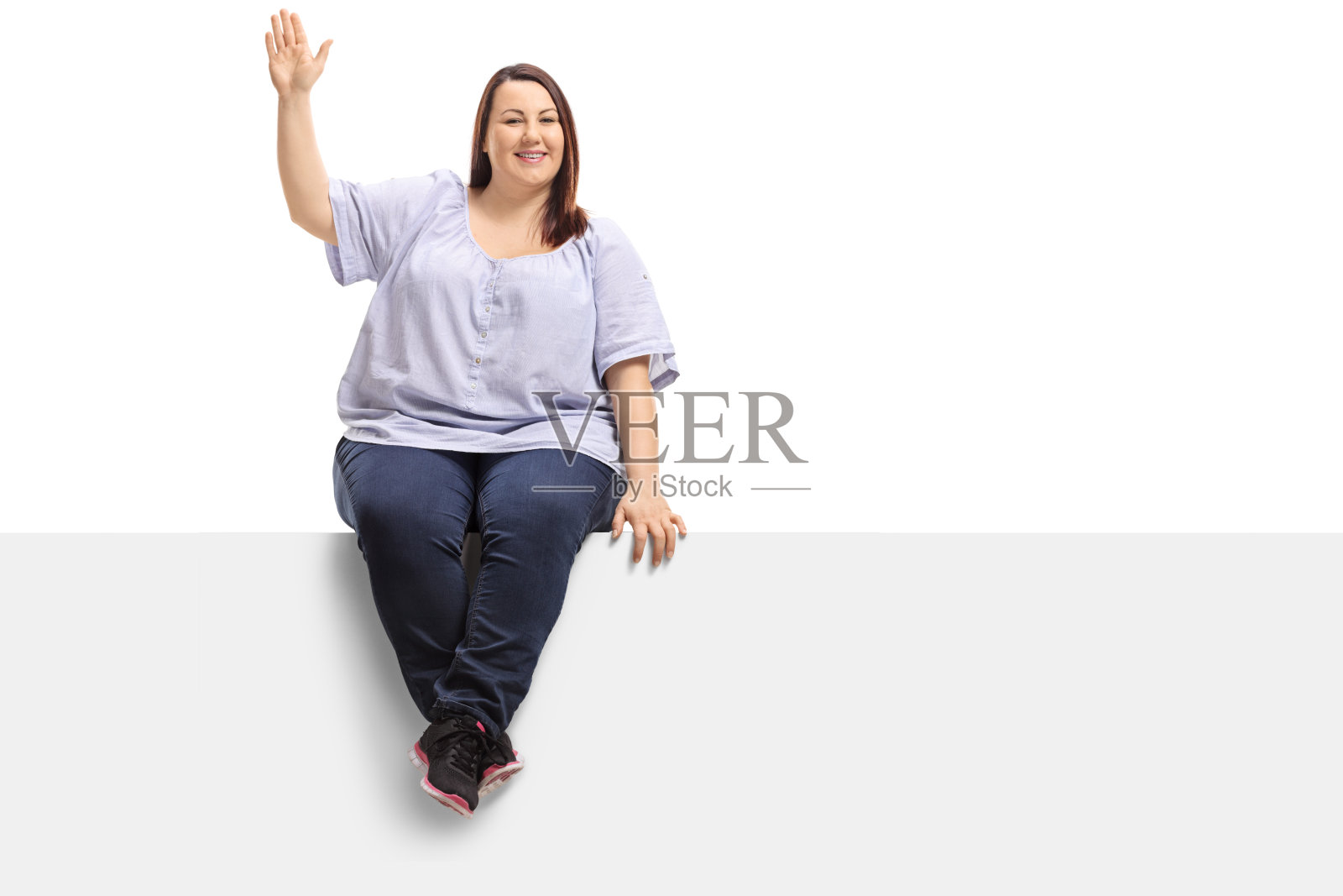 一个超重的女人坐在一个控制板上，对着镜头挥手照片摄影图片