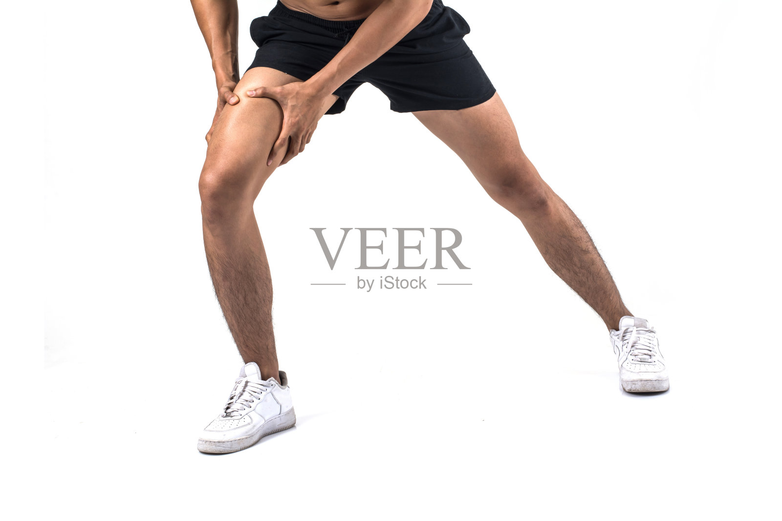 年轻的运动员用强壮的运动腿抱着膝盖，双手在疼痛后韧带受伤孤立在白色。照片摄影图片