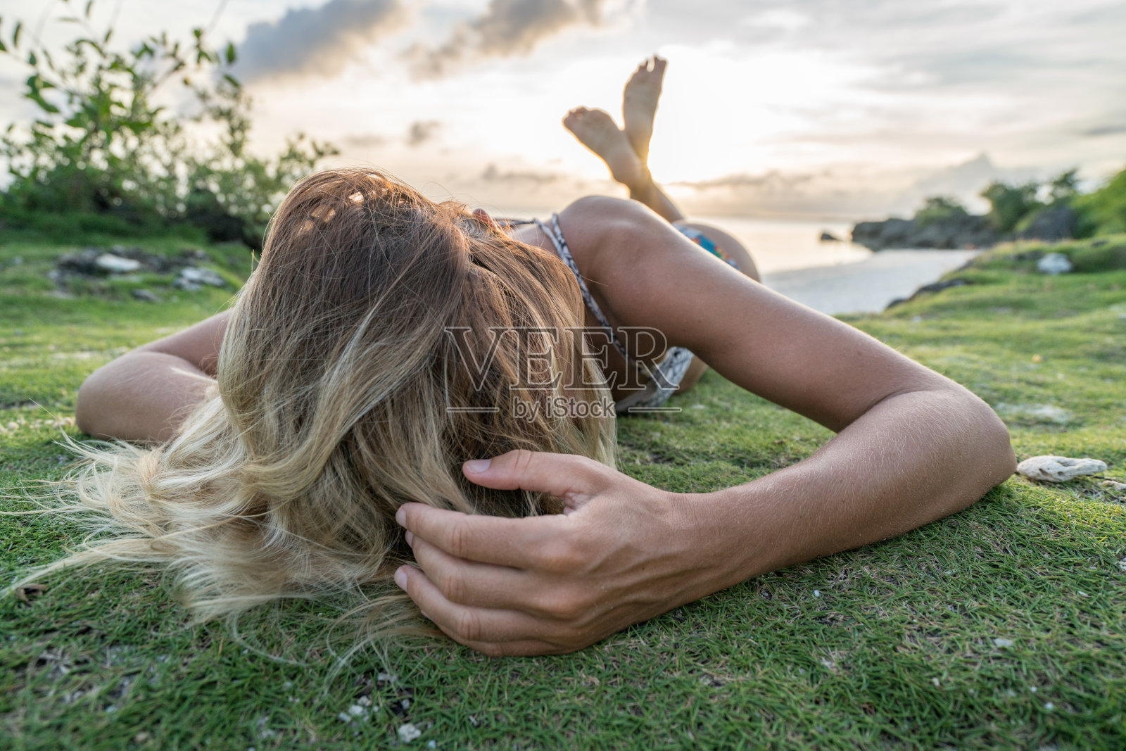 年轻女子在热带岛屿放松日落，性感照片摄影图片