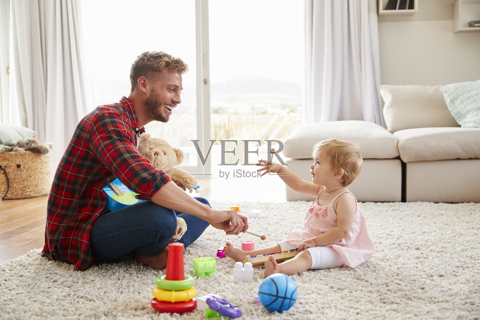 父亲和小女儿在家里玩玩具乐器照片摄影图片