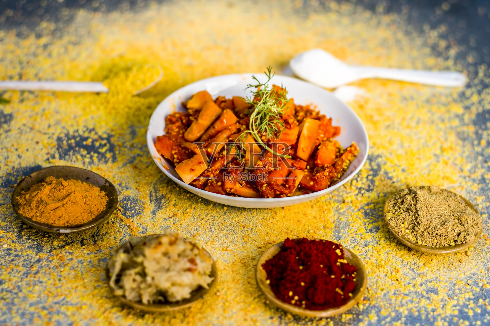 传统/地区胡萝卜腌菜，胡萝卜亚种。用红辣椒粉姜黄粉和姜蒜酱做成的腌黄瓜放在银色的木地板上。照片摄影图片