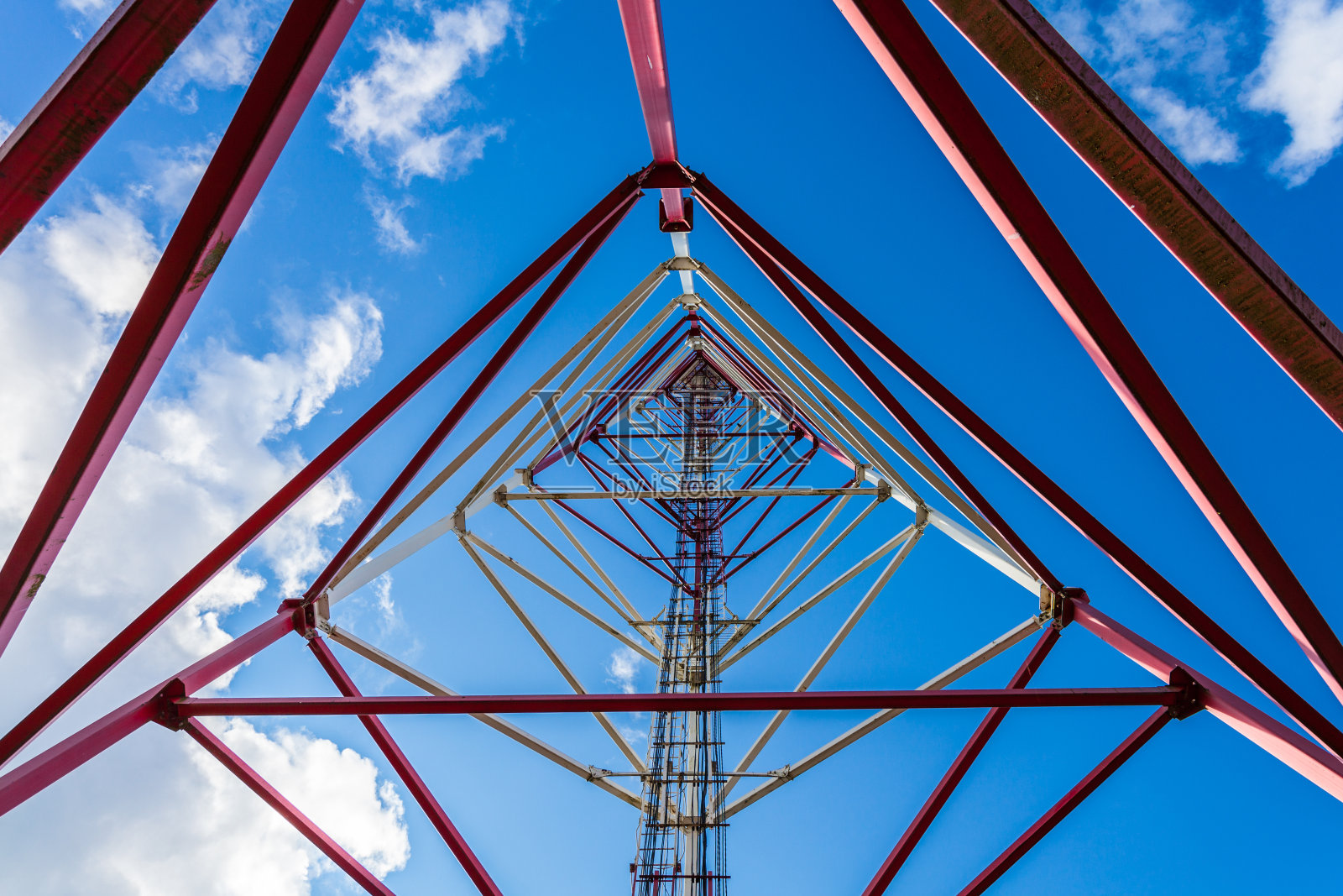 电信塔用平板天线和无线电天线以及2G、3G、4G、5G移动通信卫星天线，塔周围用红色围栏对抗蓝天白云照片摄影图片