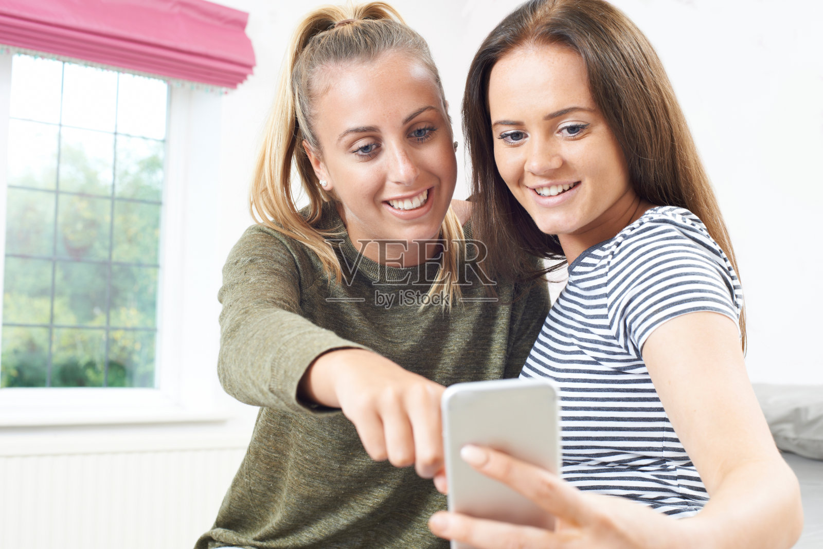 十几岁的女孩在看手机短信照片摄影图片