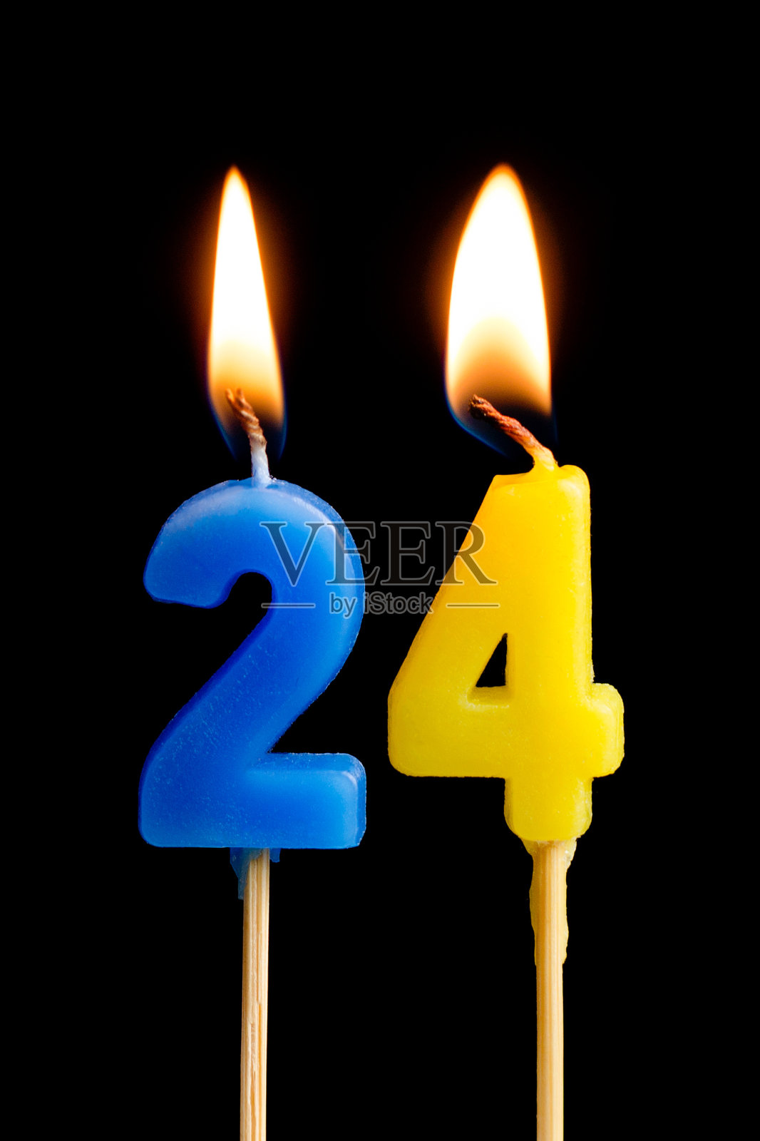 燃烧蜡烛的形式24 24(数字，日期)为蛋糕孤立在黑色的背景。庆祝生日、周年纪念、重要日期、节日、餐桌摆设的概念照片摄影图片
