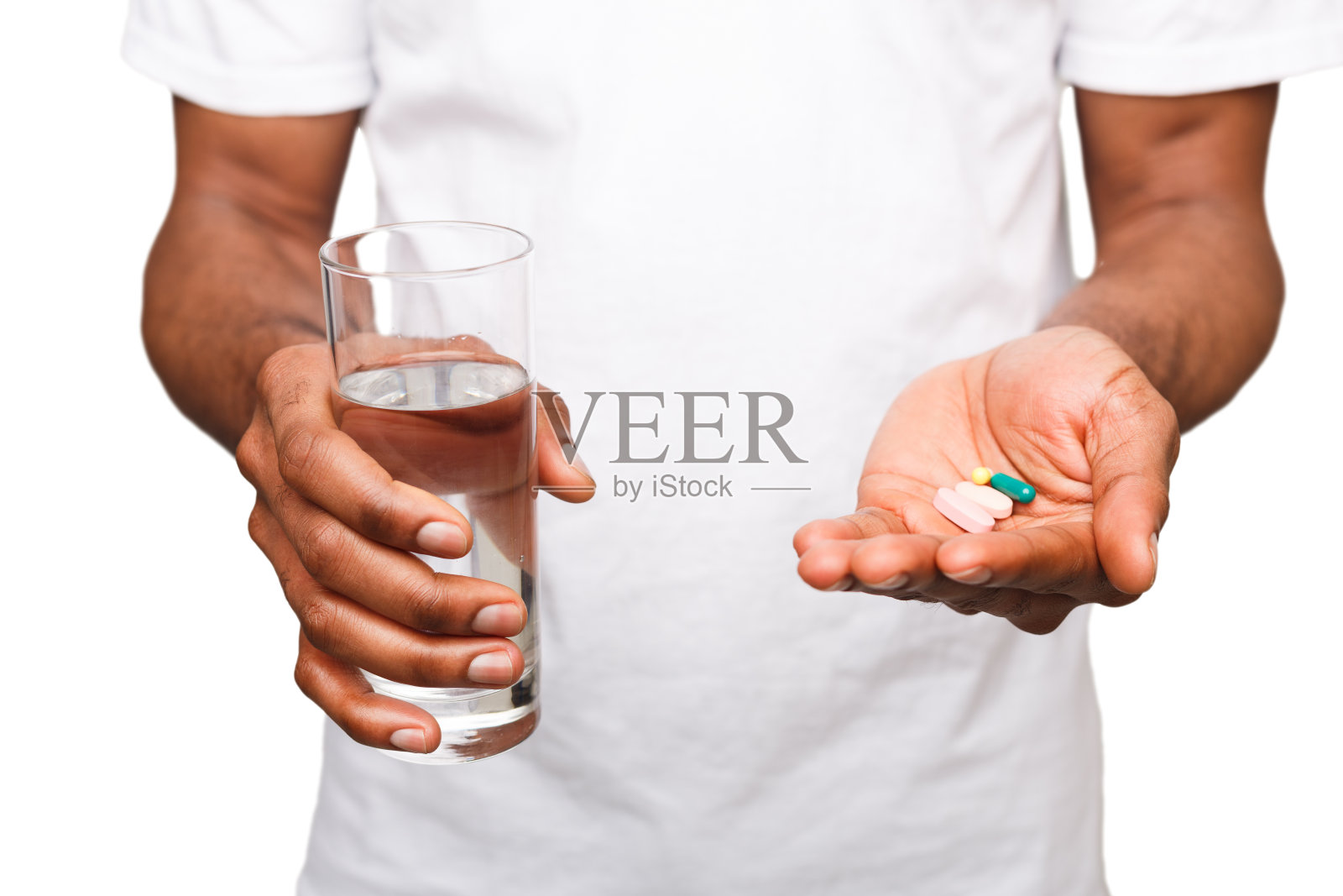 一个黑人拿着一颗药丸，孤立在白人背景下照片摄影图片