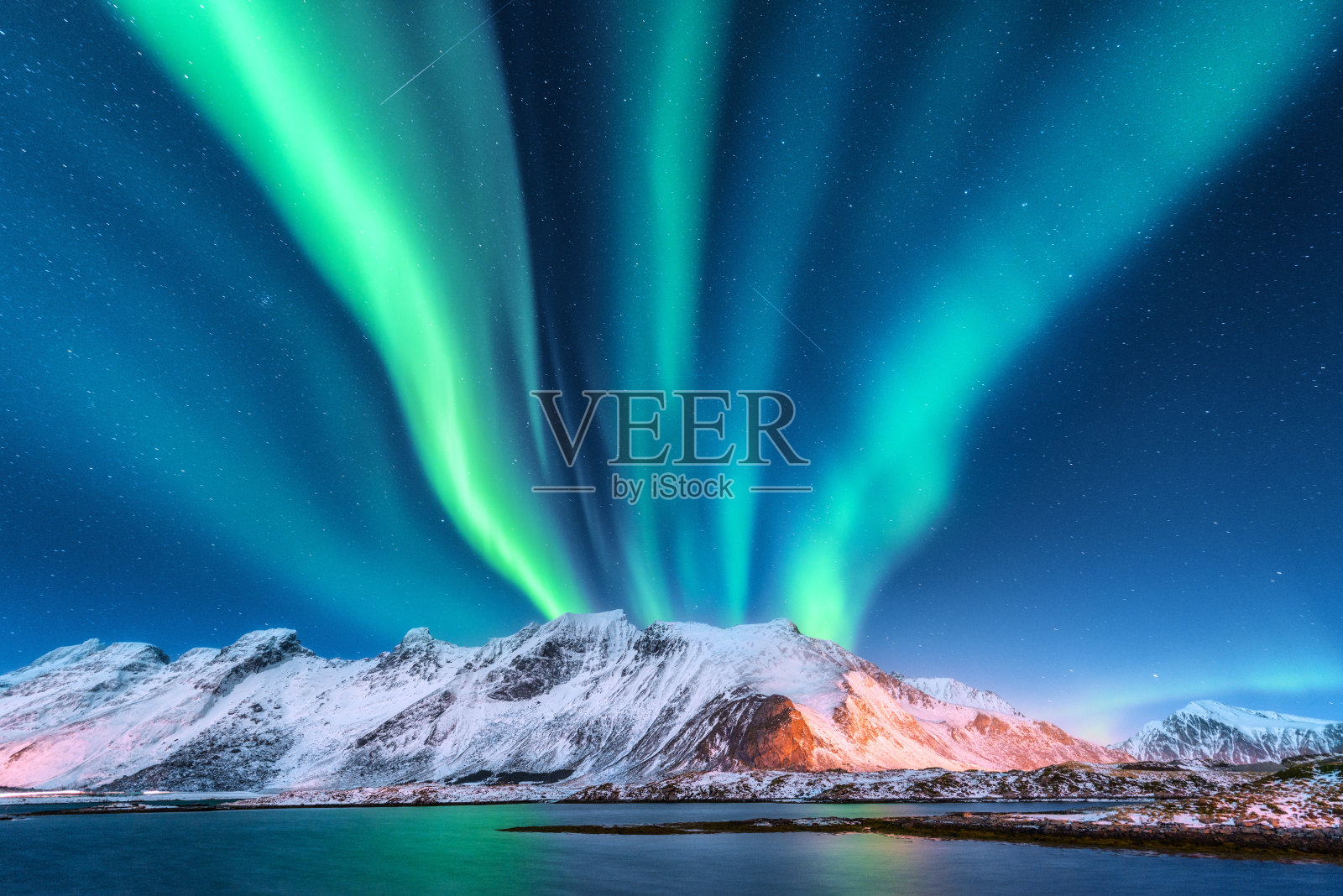 北极光。罗弗敦群岛,挪威。极光。绿色的北极光。星空与极地光。夜晚冬季景观与极光，海与天空反射和雪山。自然背景照片摄影图片