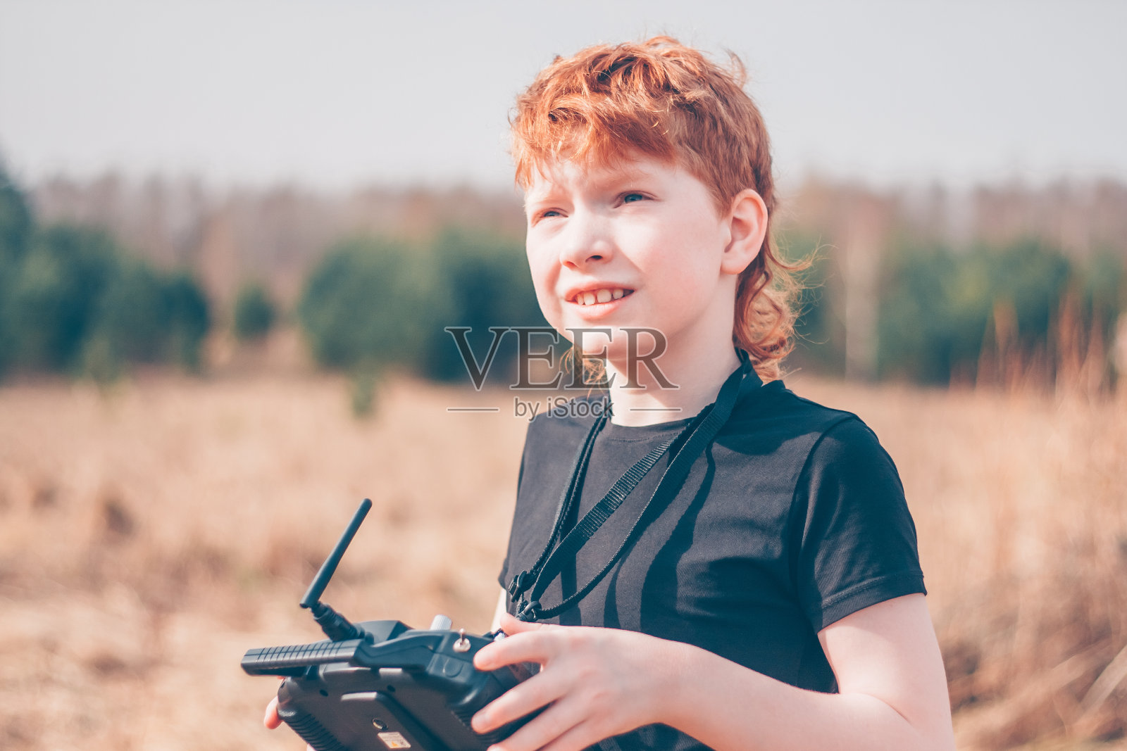 红发男孩运动员飞机模型师控制一个无线电控制模型的飞机在天空照片摄影图片