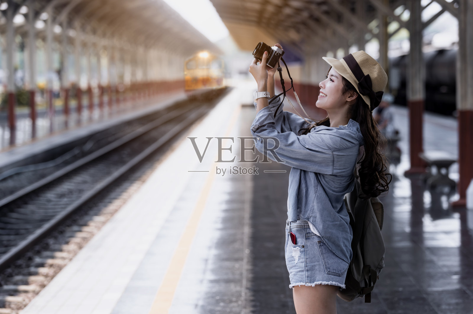 年轻美丽的女人旅行者背包拿着照相机和拍照照片摄影图片