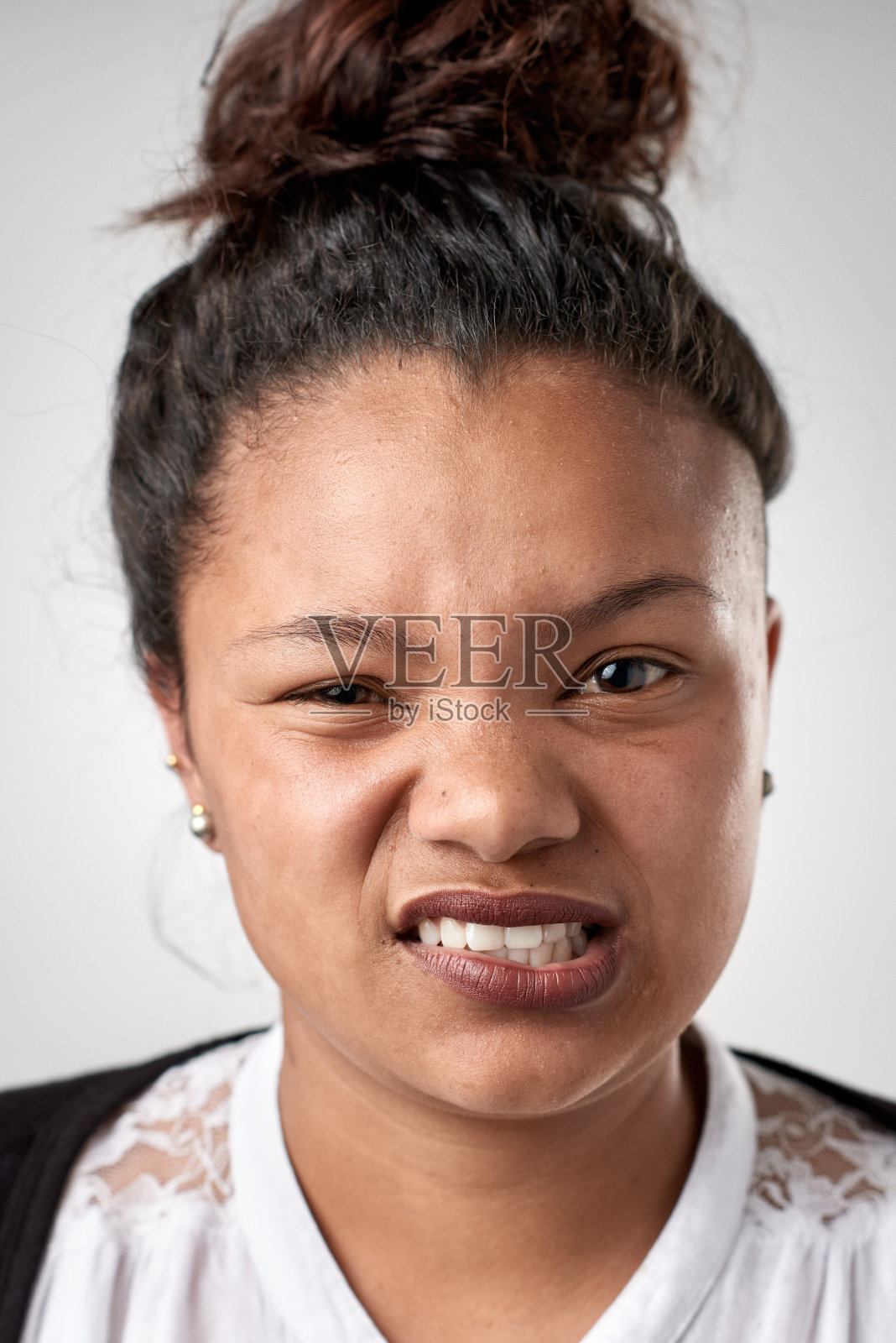 混合种族的女学生做傻傻的表情的工作室肖像照片摄影图片