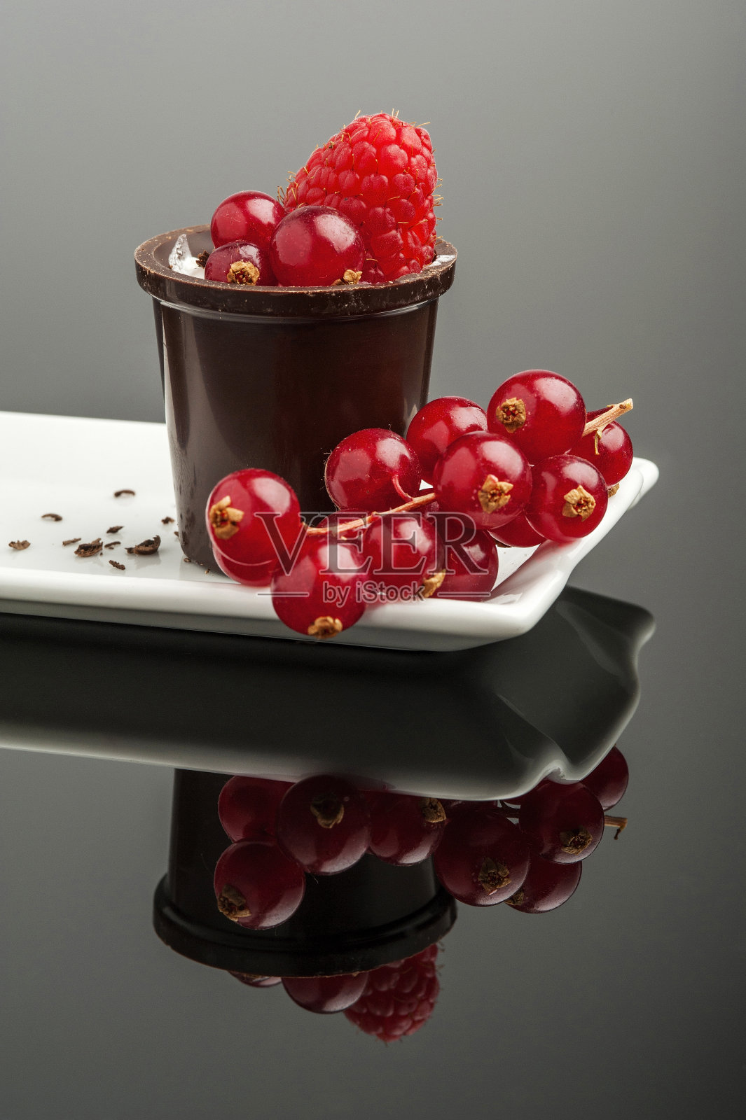 特写红醋栗与覆盆子在巧克力容器照片摄影图片