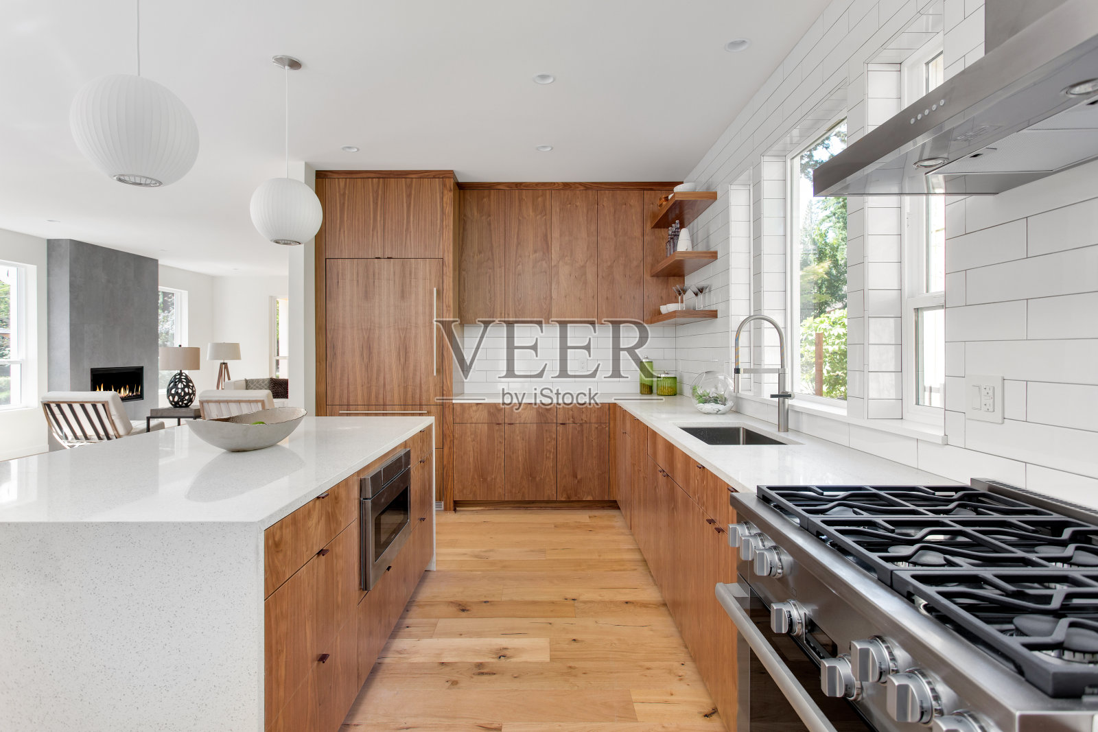 美丽的厨房在新的豪华家庭岛，吊灯，和硬木地板照片摄影图片