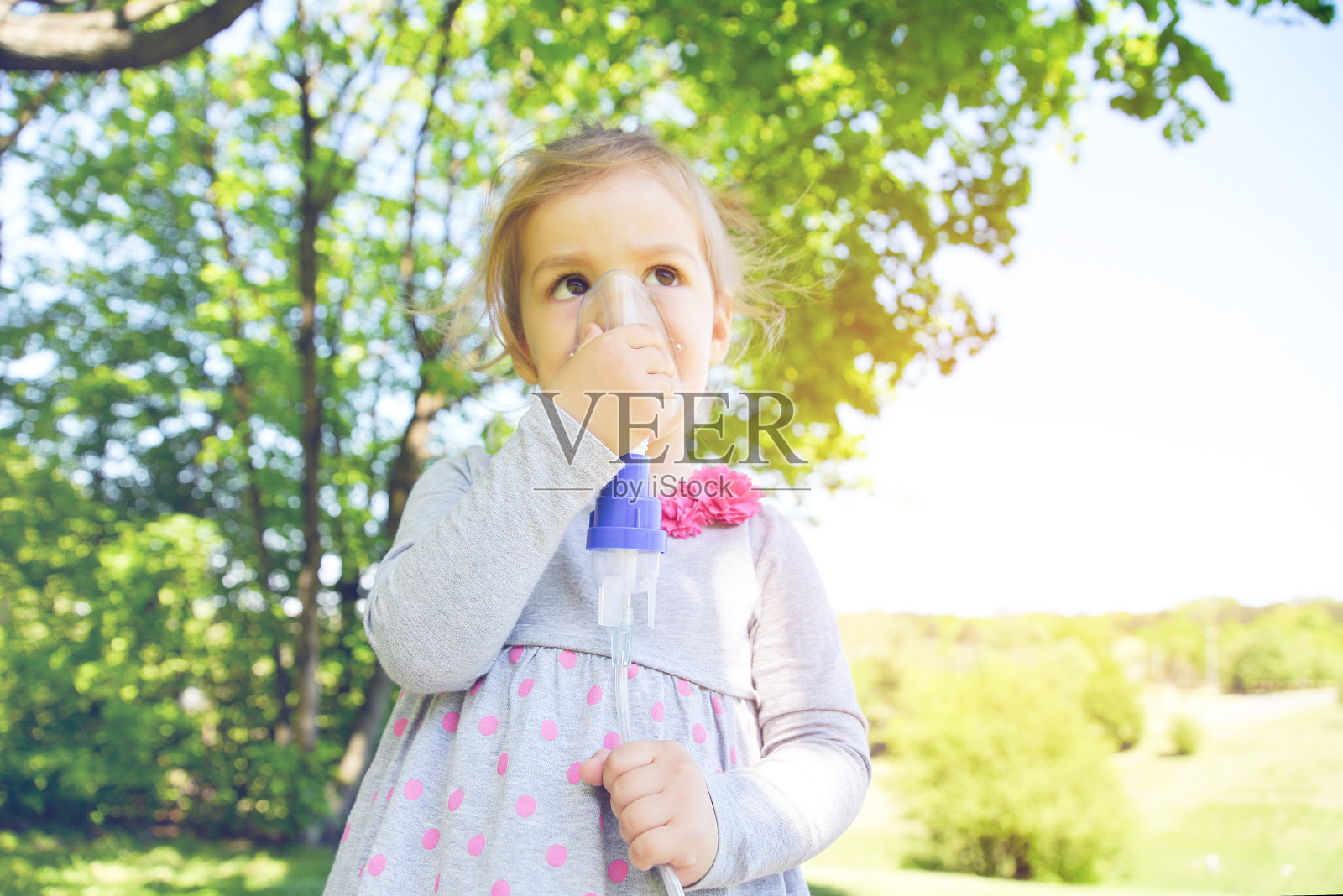 一个女孩在公园里使用哮喘吸入器照片摄影图片