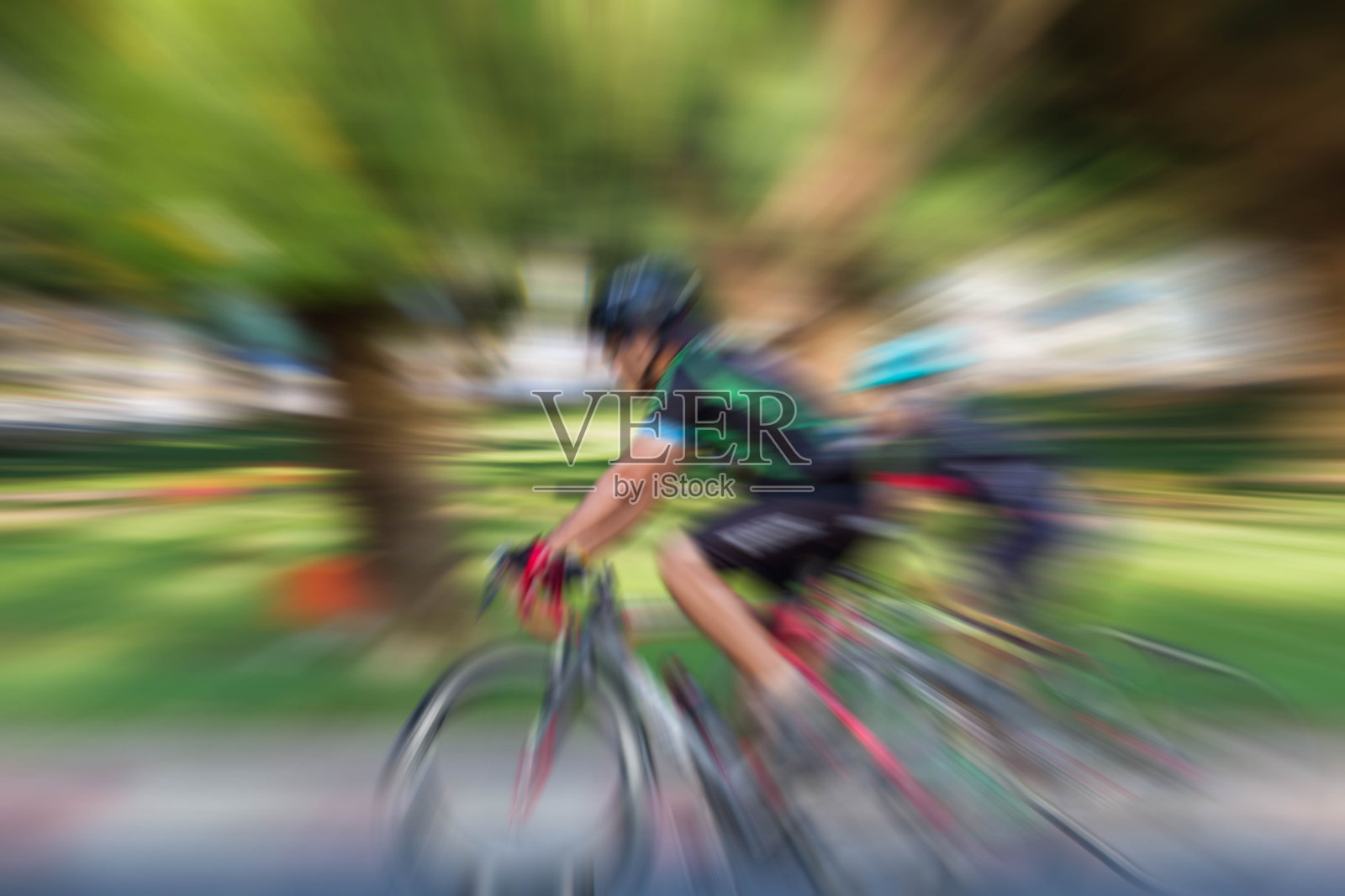运动变焦模糊了在公园里骑自行车的人照片摄影图片