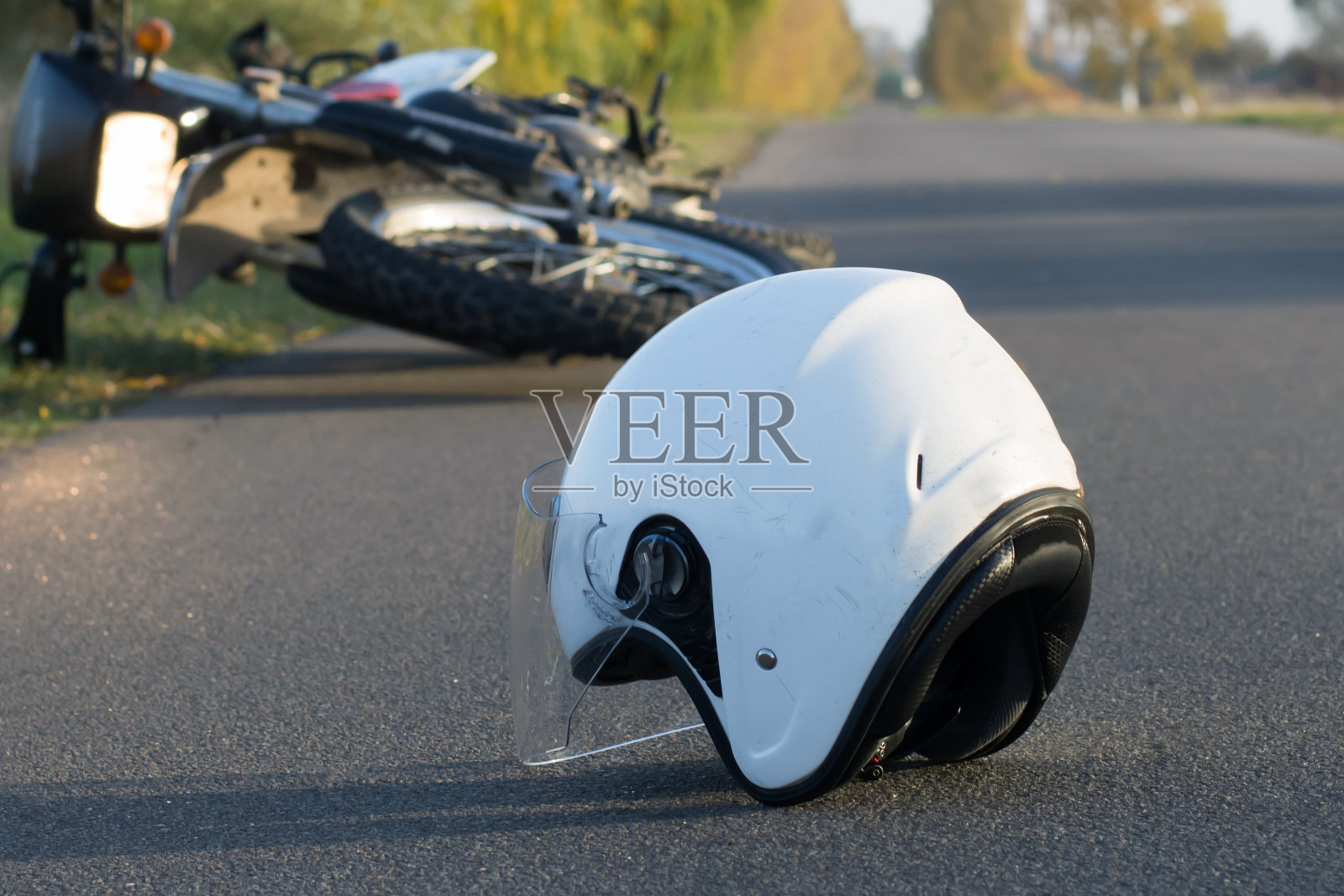 照片中的头盔和摩托车上的道路，道路事故的概念照片摄影图片