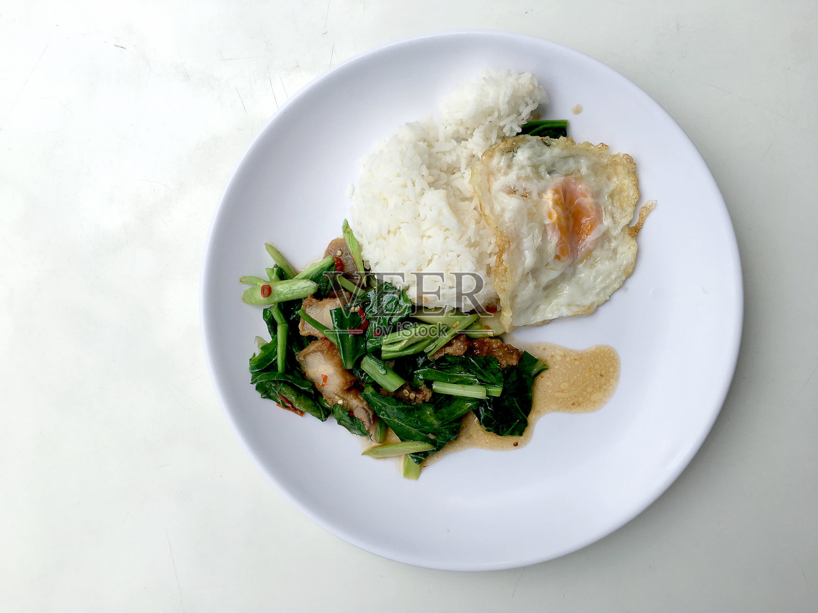 炒凯兰和香酥猪肉，炒白饭，白底白饭。泰国风格的食物。照片摄影图片