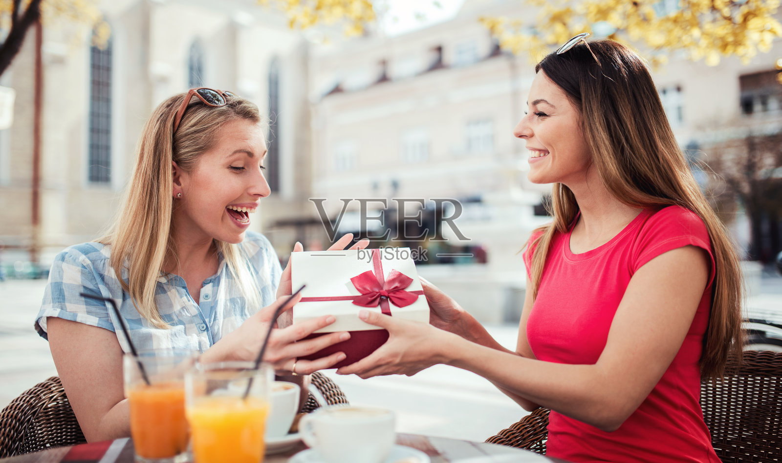两个漂亮的女孩购物后在咖啡馆喝咖啡。消费主义、购物、生活理念照片摄影图片