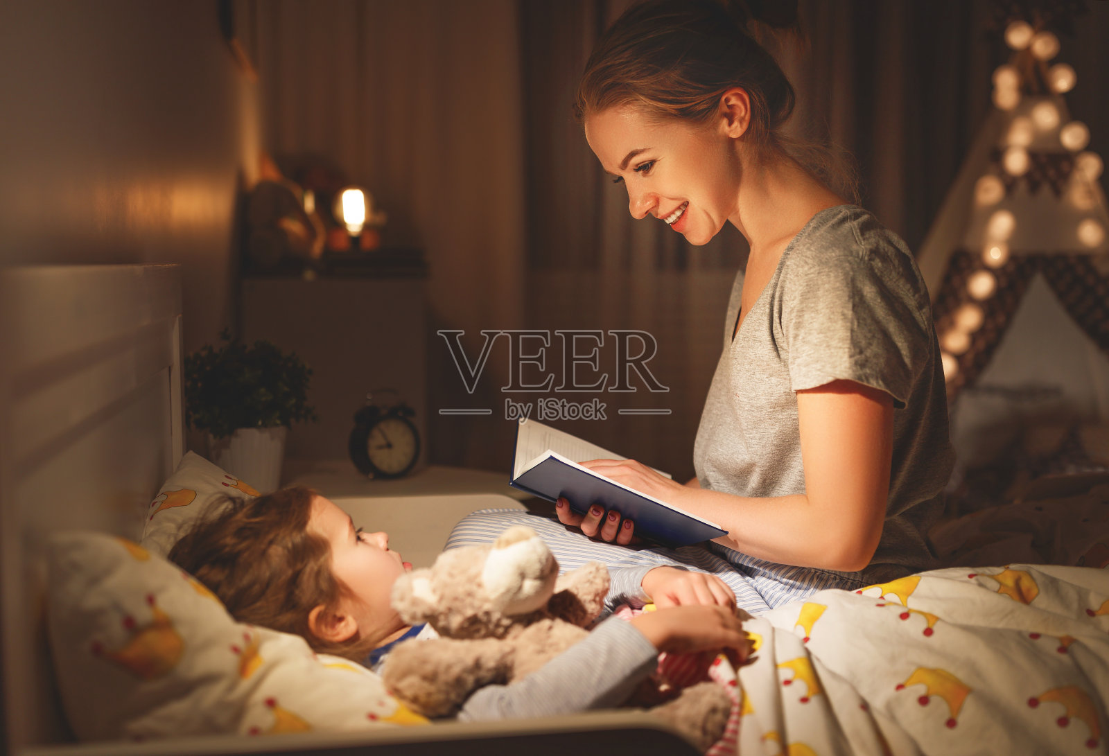 睡觉前妈妈和孩子在床上看书照片摄影图片