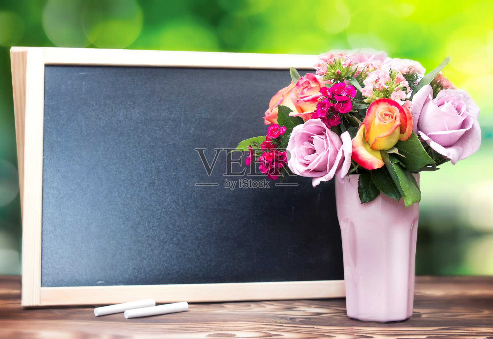 花瓶中的鲜花和黑板空白的复制空间背景。照片摄影图片