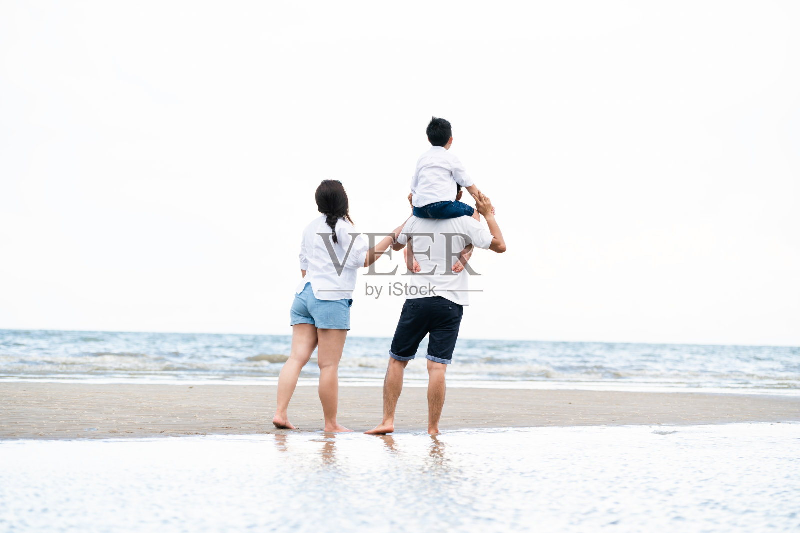 快乐的一家人在夏天去海滩度假。照片摄影图片