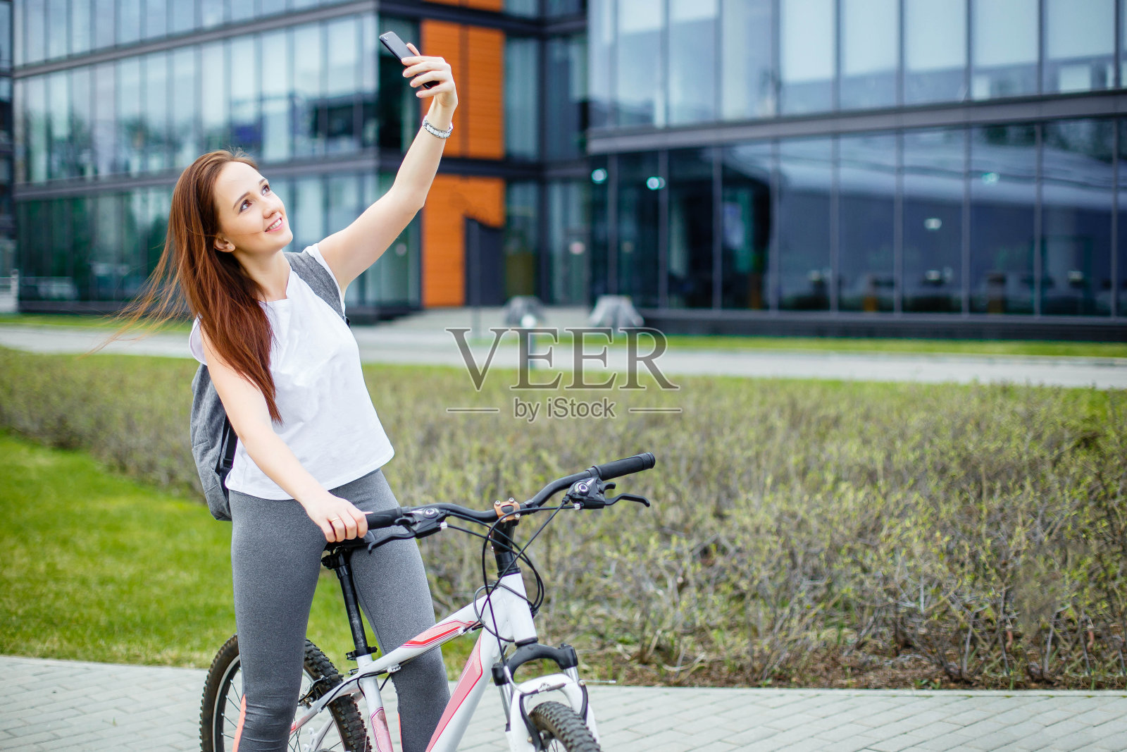 漂亮的年轻女孩骑着自行车在城里自拍照片摄影图片