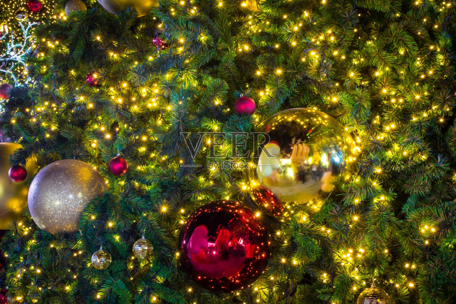 圣诞树上的球和灯闪闪发光。照片摄影图片