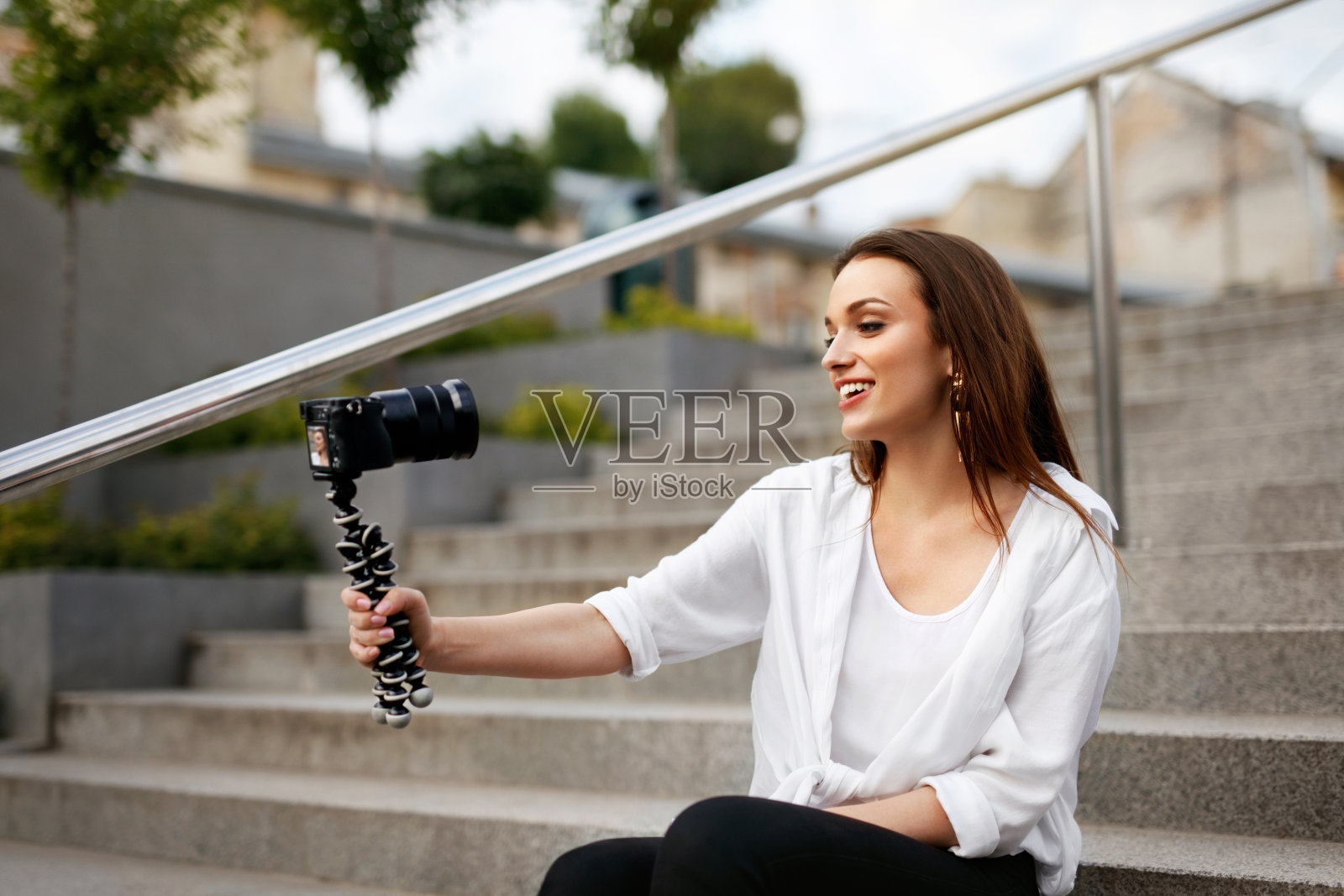 写博客。在街上拍摄录像的女人照片摄影图片