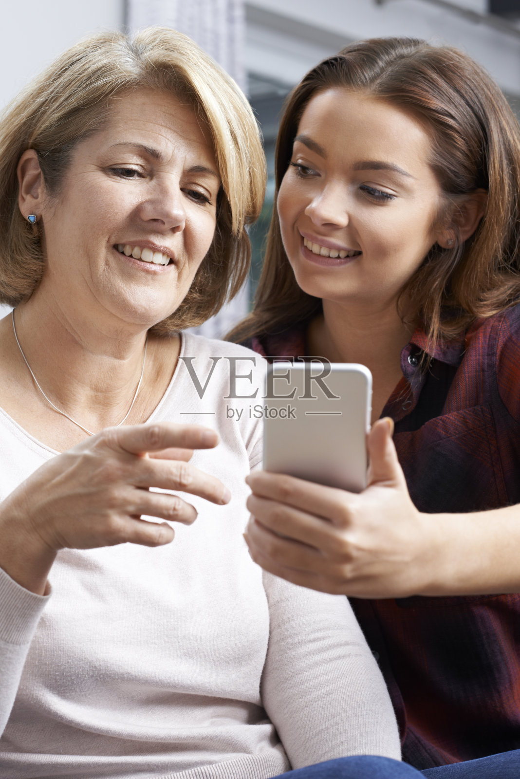 十几岁的女儿向母亲展示如何使用手机照片摄影图片