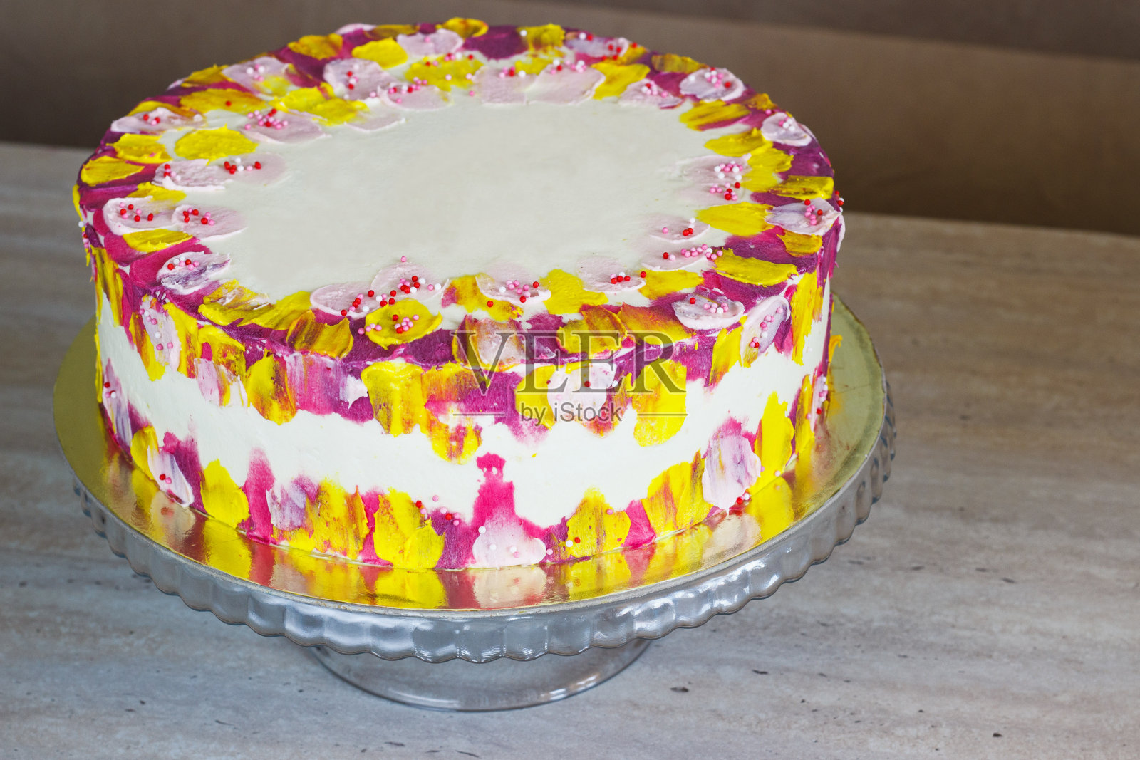 白色生日蛋糕与彩色的点缀在一个明亮的背景照片摄影图片